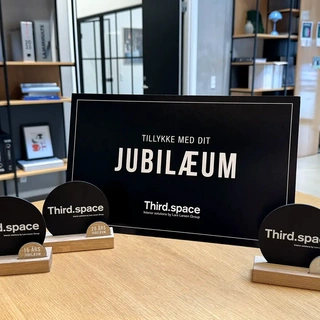 Anniversary statuettes and gift card from Third.space displayed in modern office setting – celebrating long-term employee milestones.
