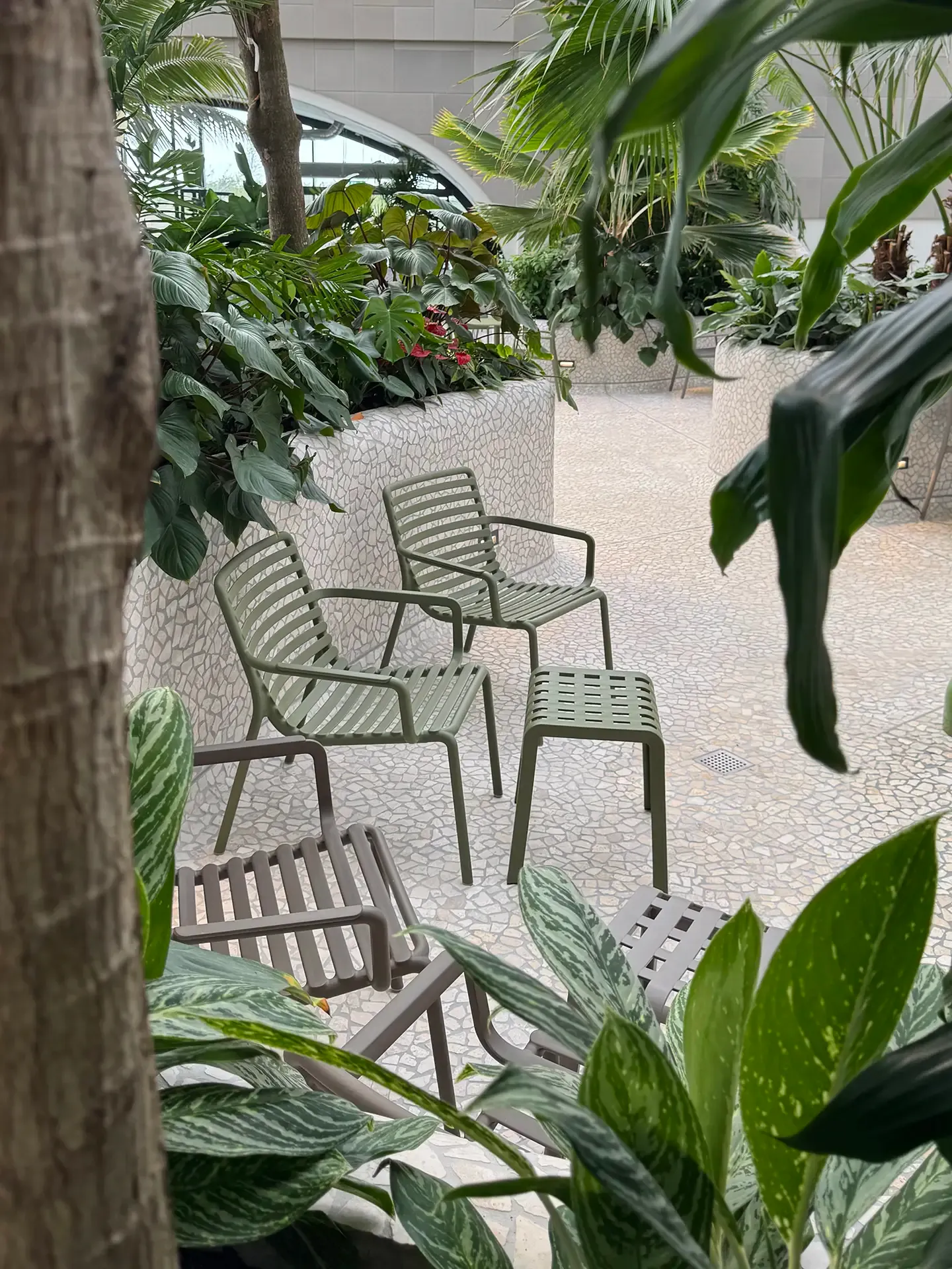 Relaxation seating arranged within an indoor spa environment featuring dense planting and terrazzo flooring at Nordborg Resort.