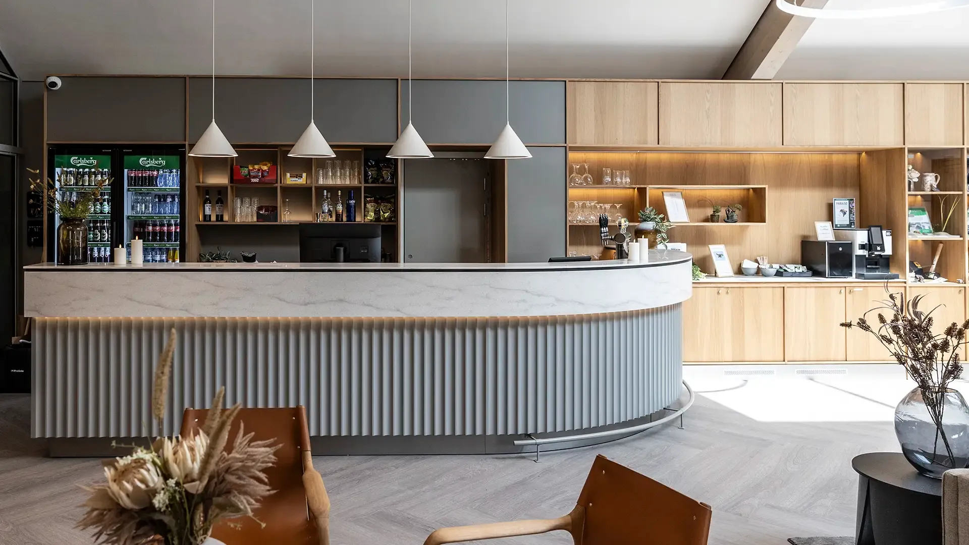 Custom-built Scandinavian hotel reception desk in light wood tones.
