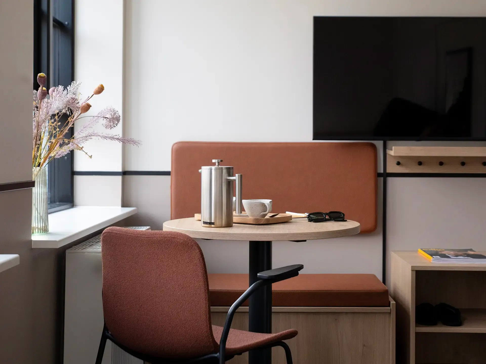 Dining area with bespoke oak and cognac leather furniture, highlighting premium materials for hotel apartments and suites.