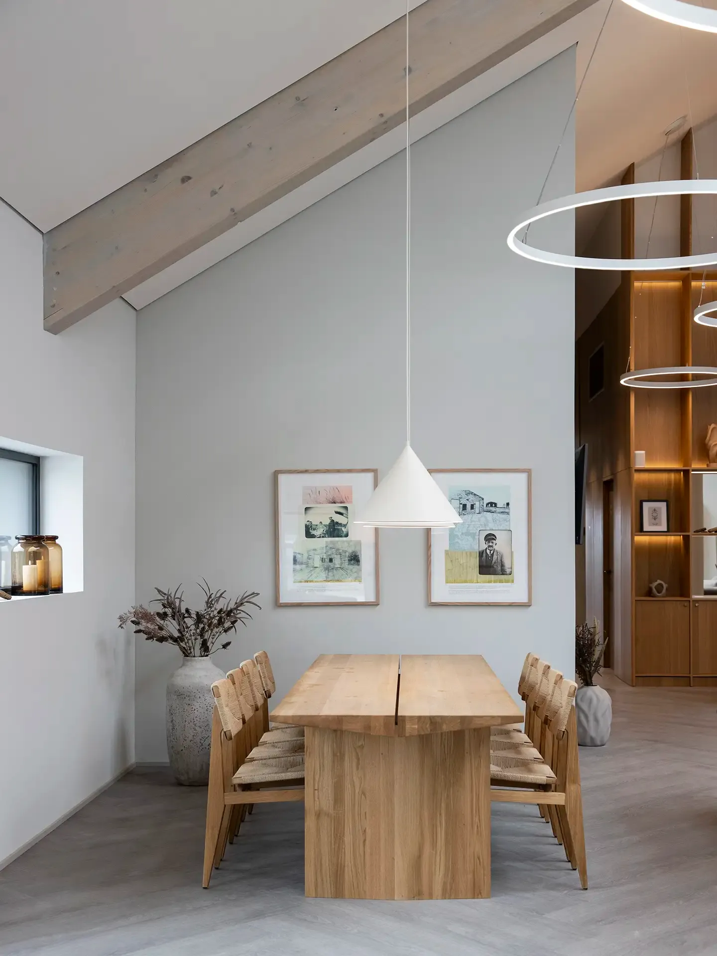 Hotel dining area with wood table and pendant lighting.
