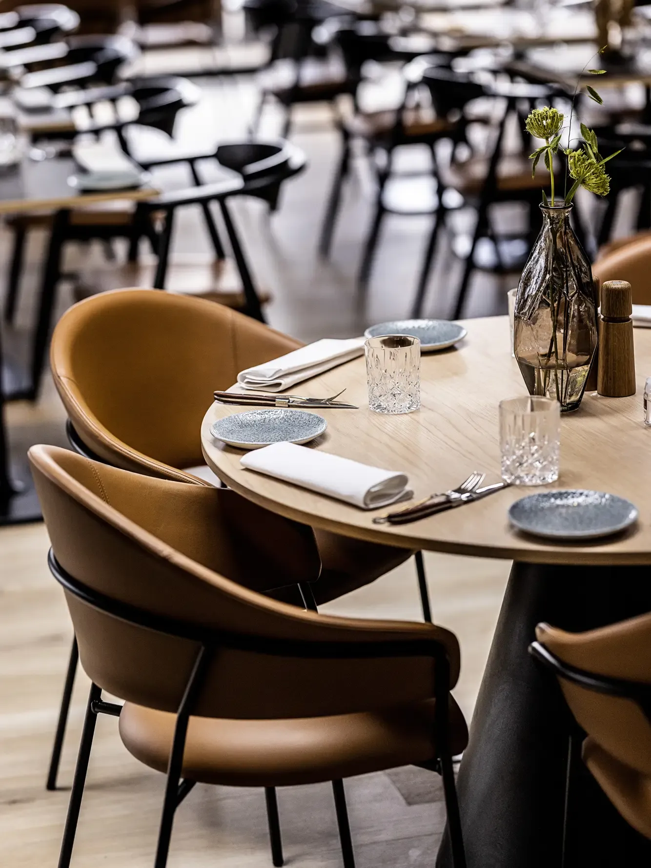 Dining chairs in cognac leather and oak dining table in the elegant restaurant at HimmerLand.