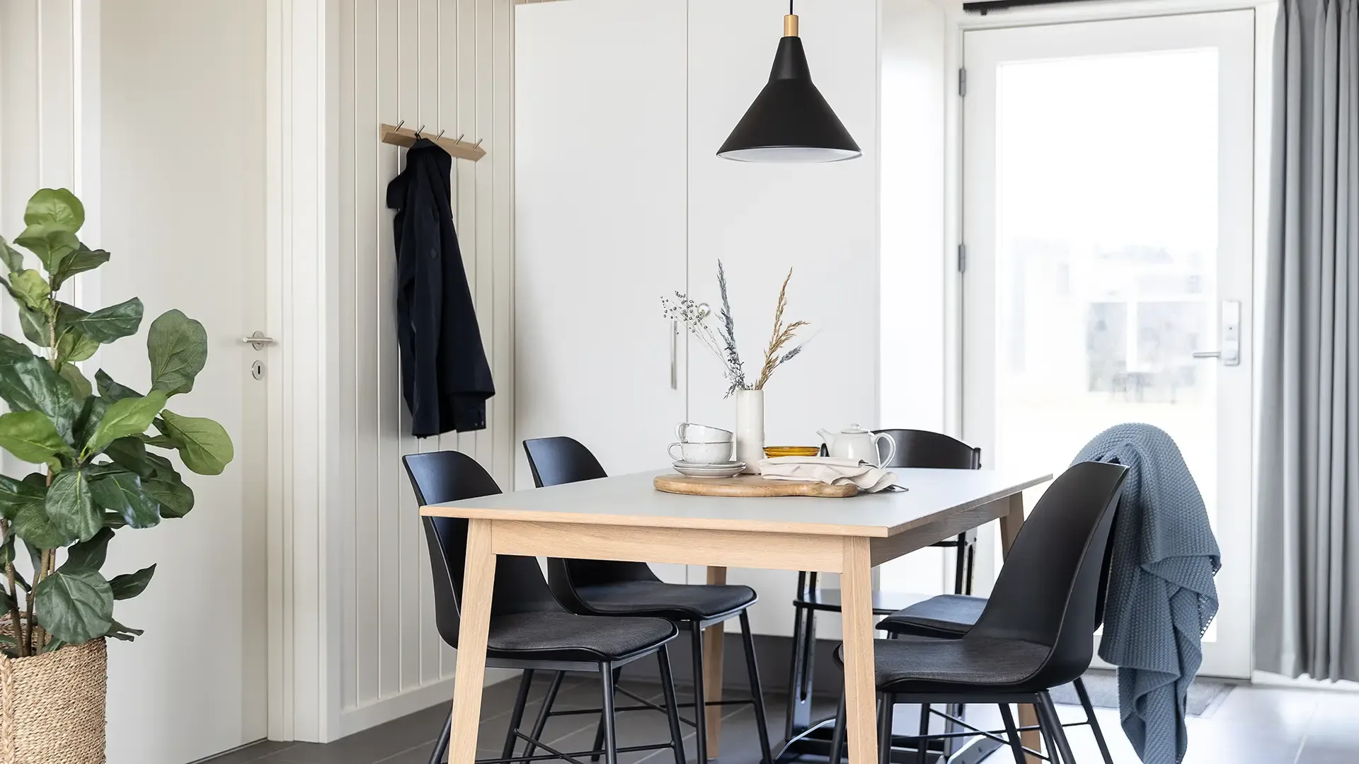 Dining table and chairs in holiday cottage with light wood design and durable quality