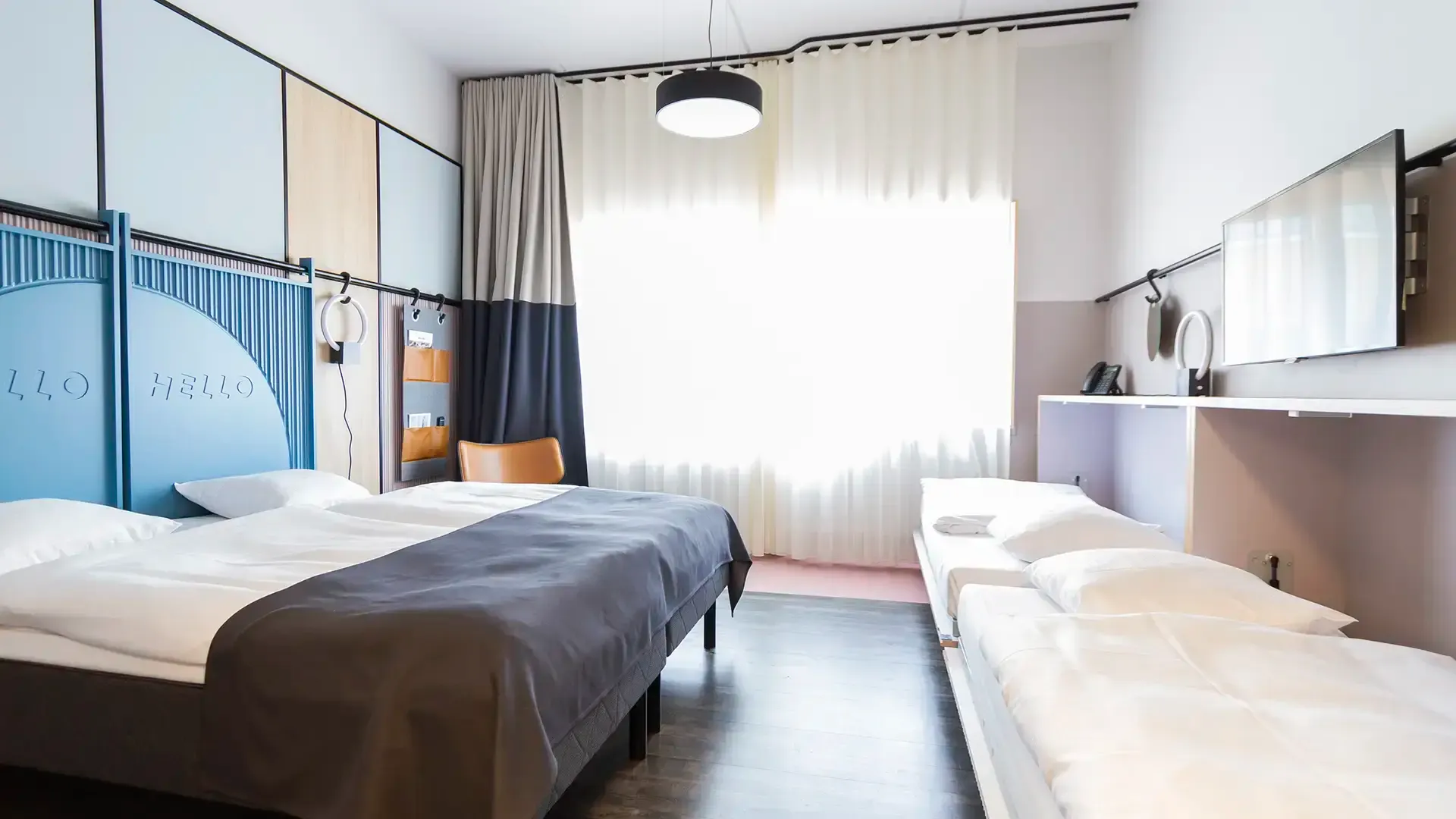 Hotel room in Scandinavian style with double bed and two extra sleeping places.