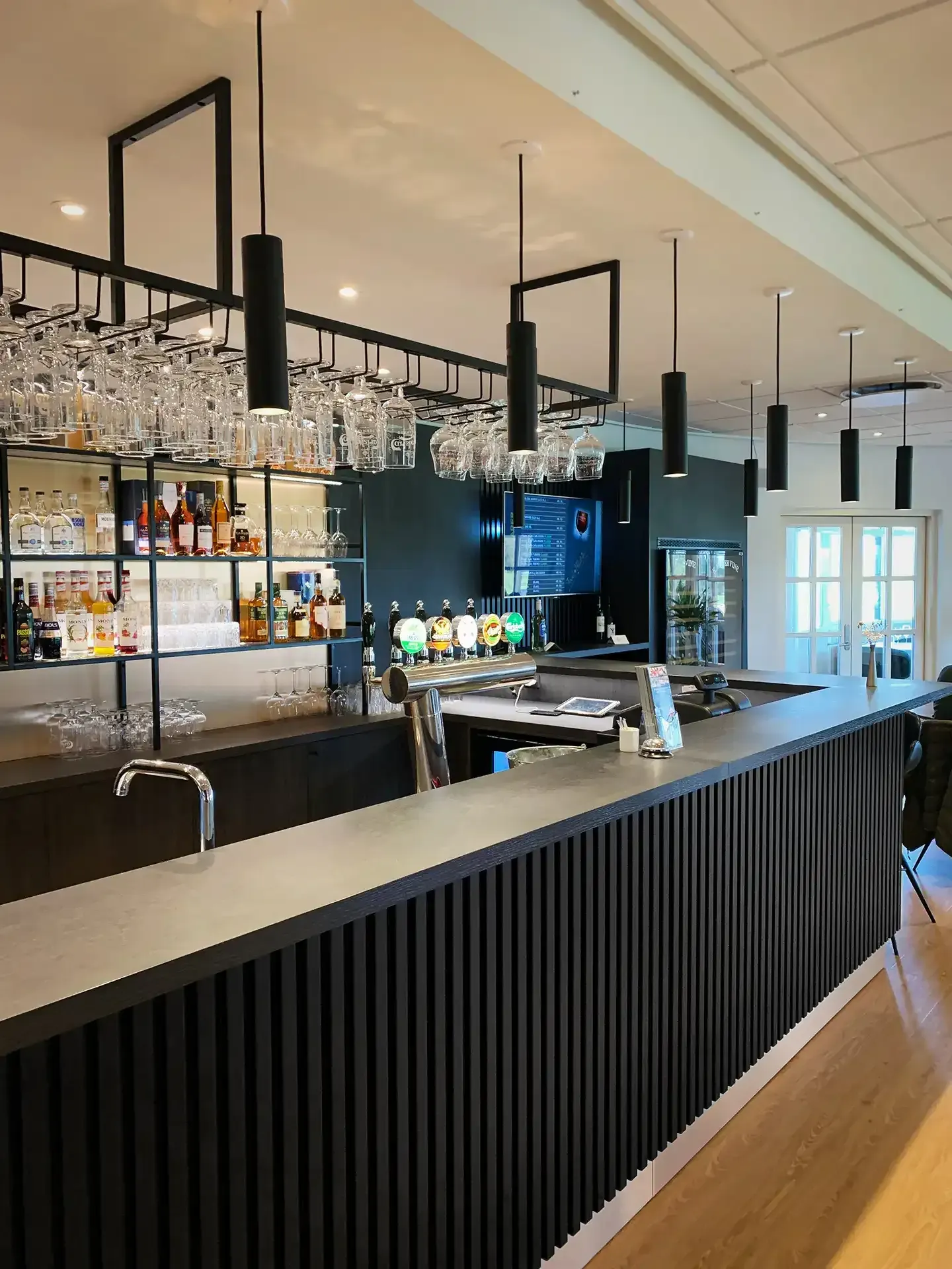 Custom made bar counter with dark wood slats in golf club restaurant