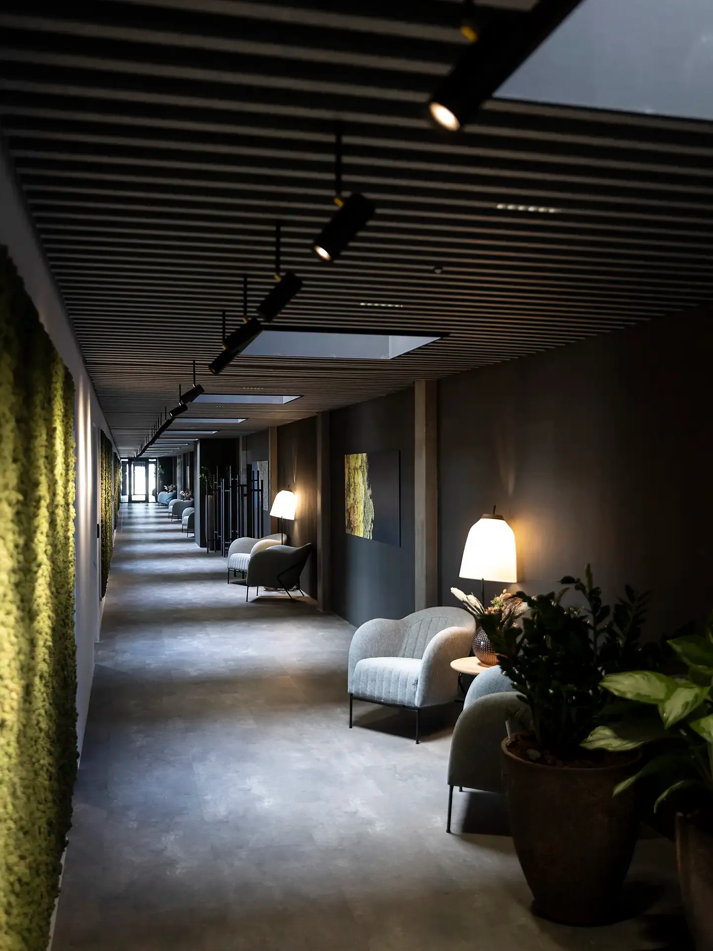 Elegant conference hallway with moss wall, exclusive lighting, and acoustic ceiling panels for a luxury feel.