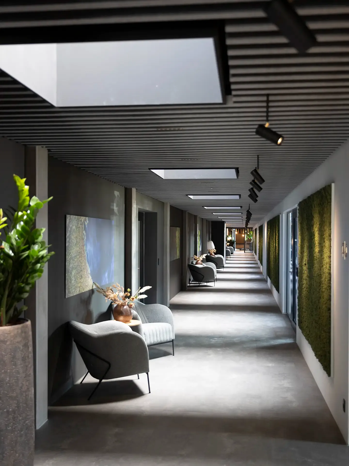 Intimate conference hallway with moss wall, soft lighting, and lounge seating for a welcoming atmosphere.