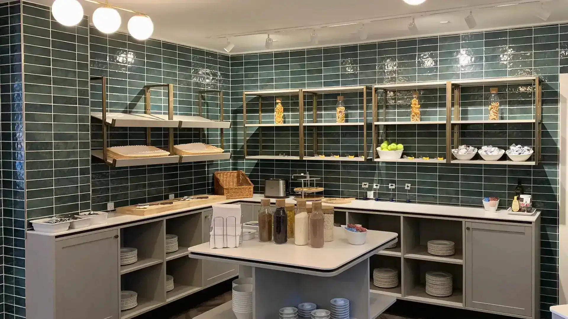 Hotel breakfast area with green tiles and brass accents, custom interior by Third.space.