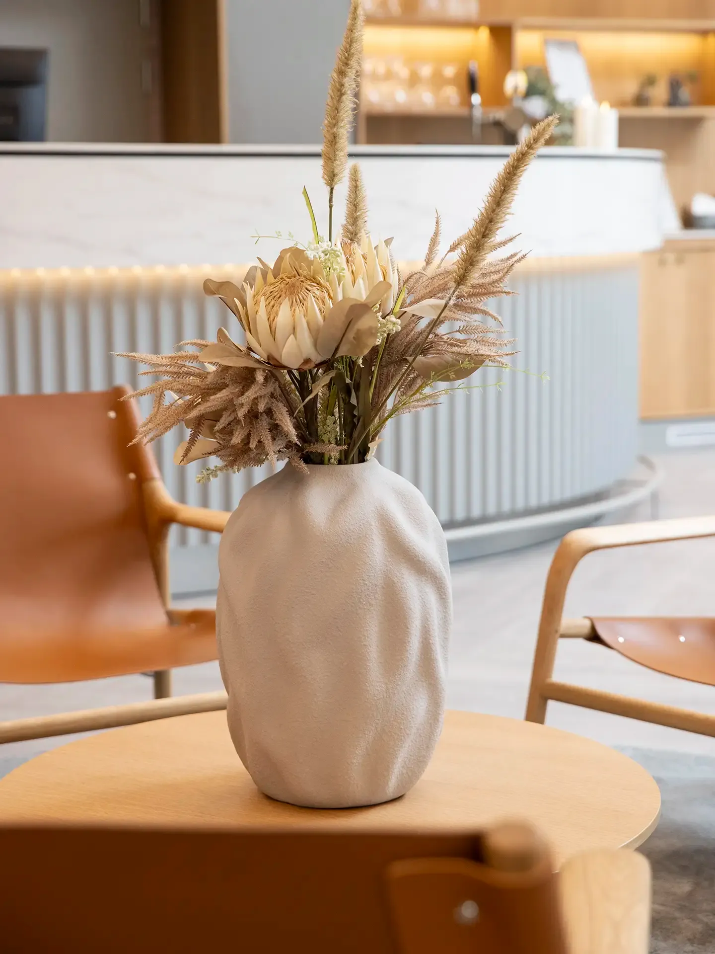 Hotel decor with ceramic vase and dried floral arrangement.