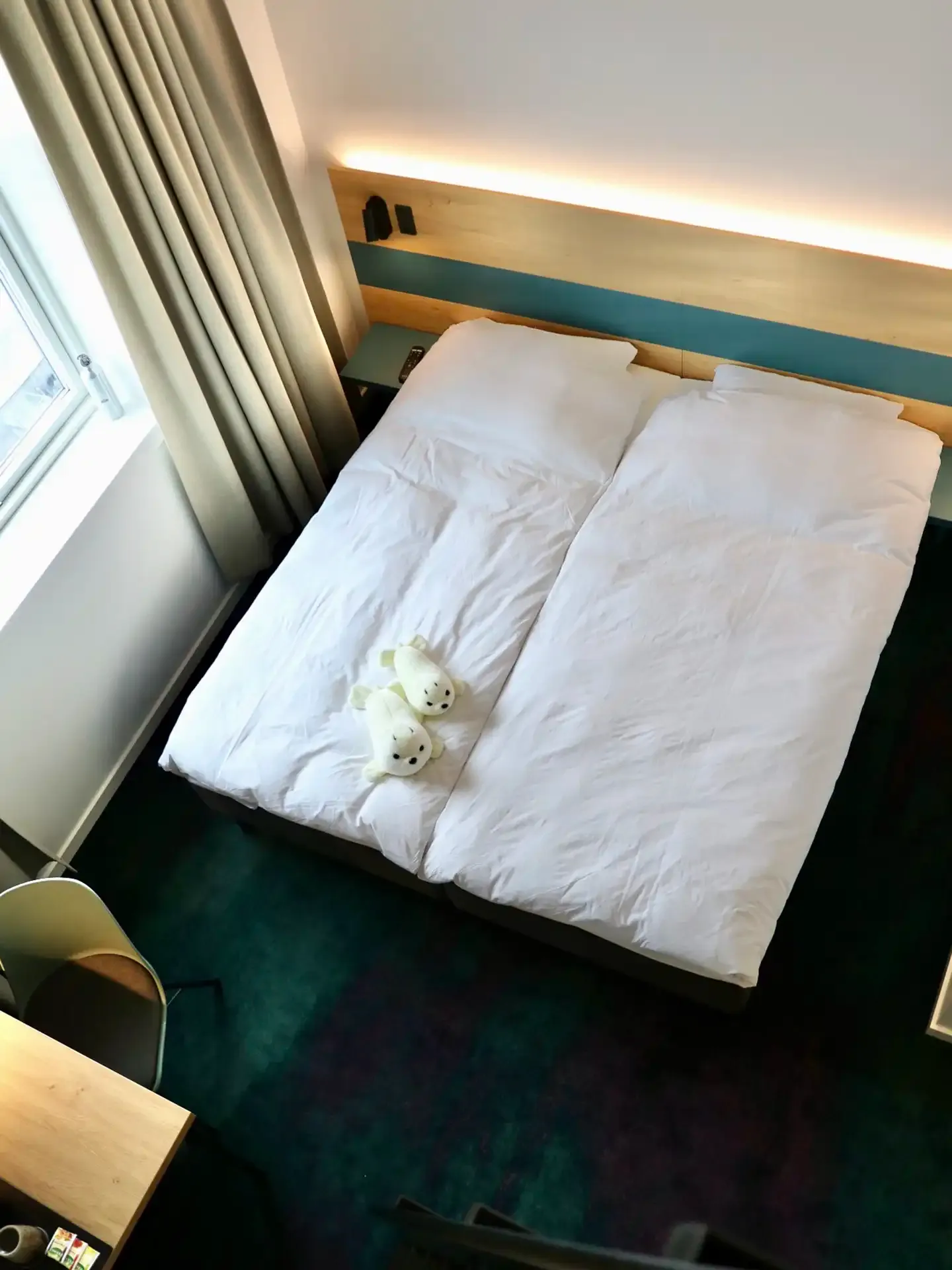 Hotel room with twin beds, oak headboard and integrated lighting, interior by Third.space inspired by Nordic calm