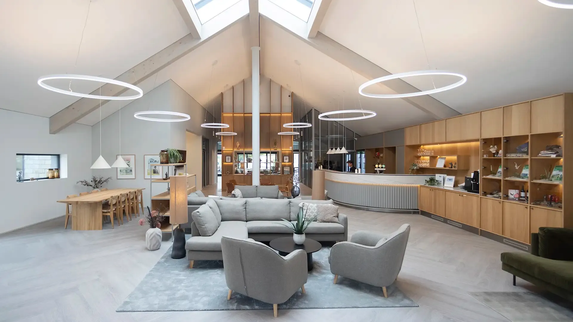 Hotel lobby nordic design interior featuring custom-made built-in shelving unit. High ceilings and roof windows.