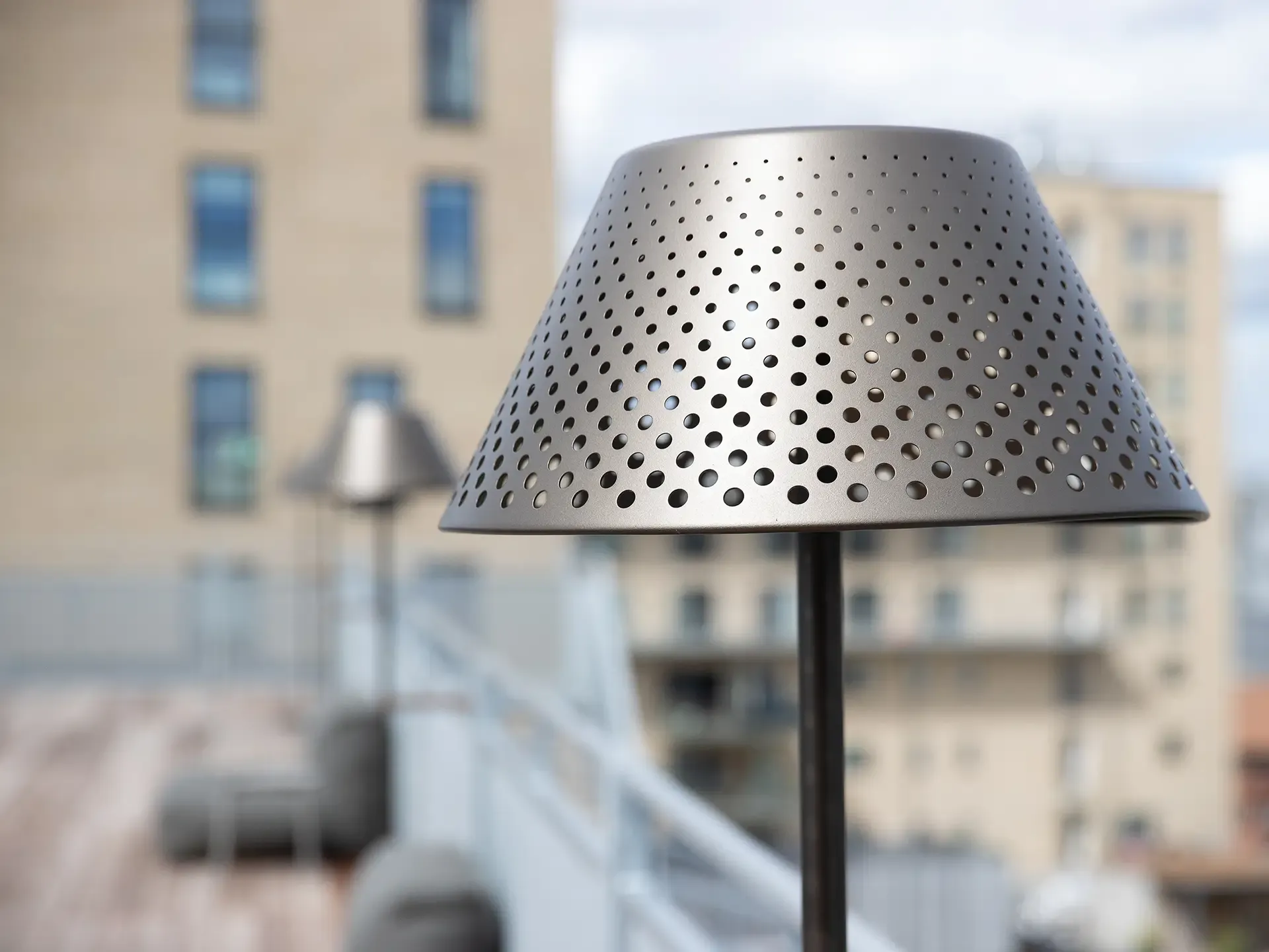 Close-up of wall lamp mounted on wooden slat panel at modern hotel rooftop.
