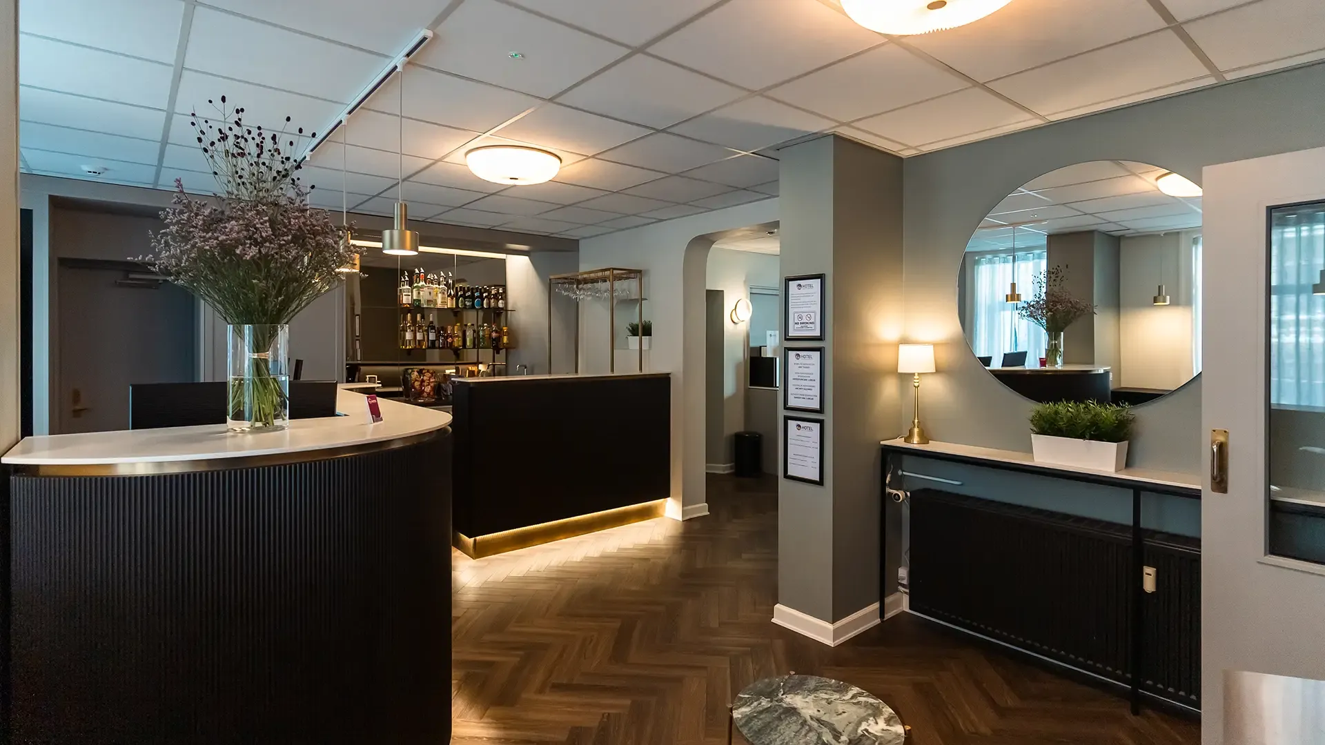 Custom-designed hotel reception bar in oak and brass, created by Third.space.