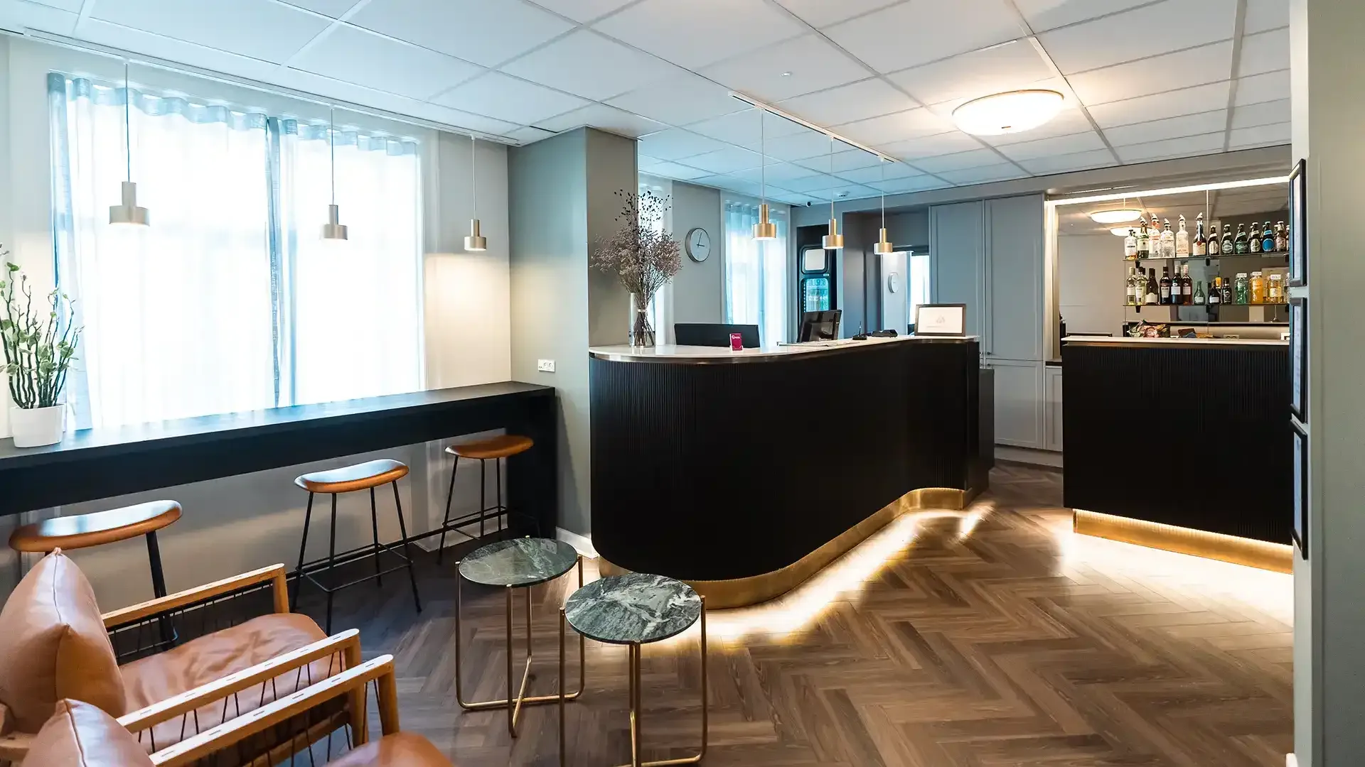 Black wood reception counter with brass detail, compact and elegant solution.