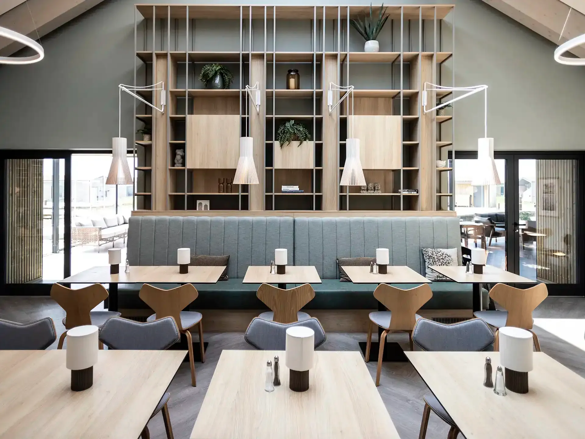 Hotel restaurant interior with built-in shelving and warm lighting.