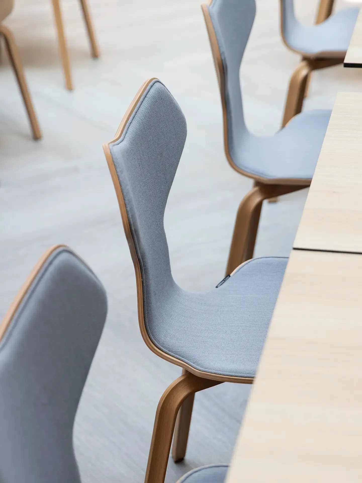Hotel restaurant with modern upholstered chairs in neutral tones.