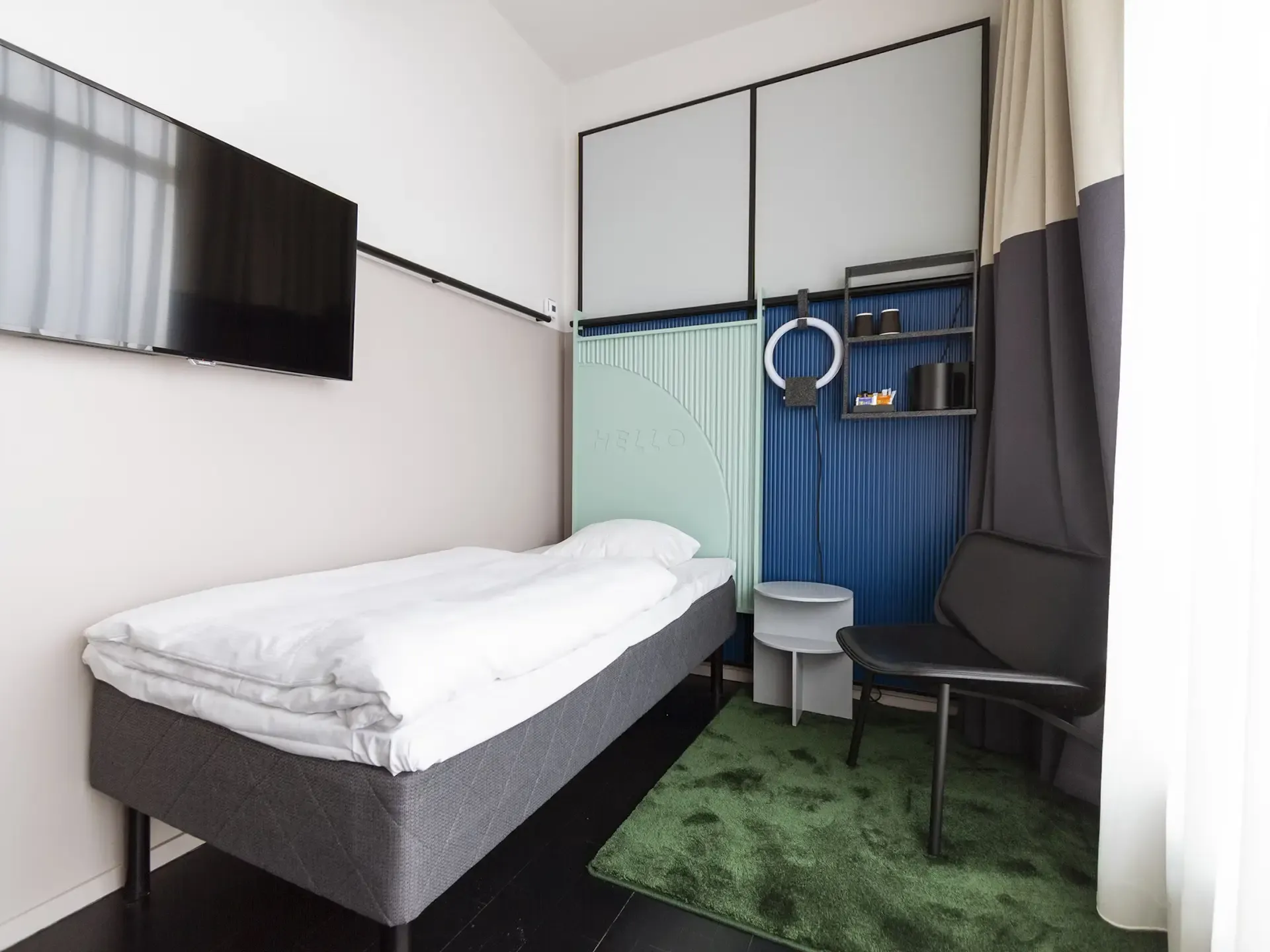 Compact hotel room with Nordic-inspired interior design, featuring clean lines, soft tones, and functional furniture for a stylish guest experience.