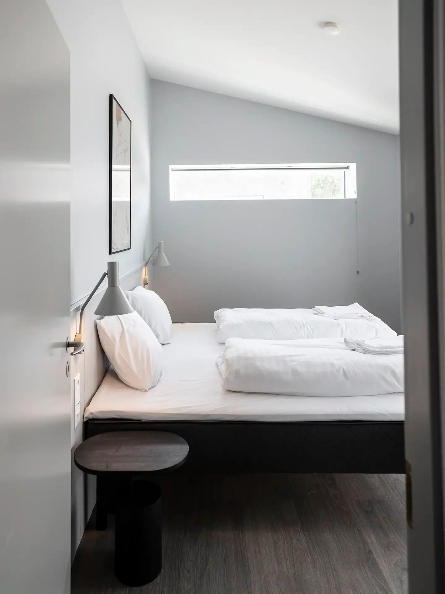 Minimalist hotel room design with double bed and neutral tones. Room for relaxation. 