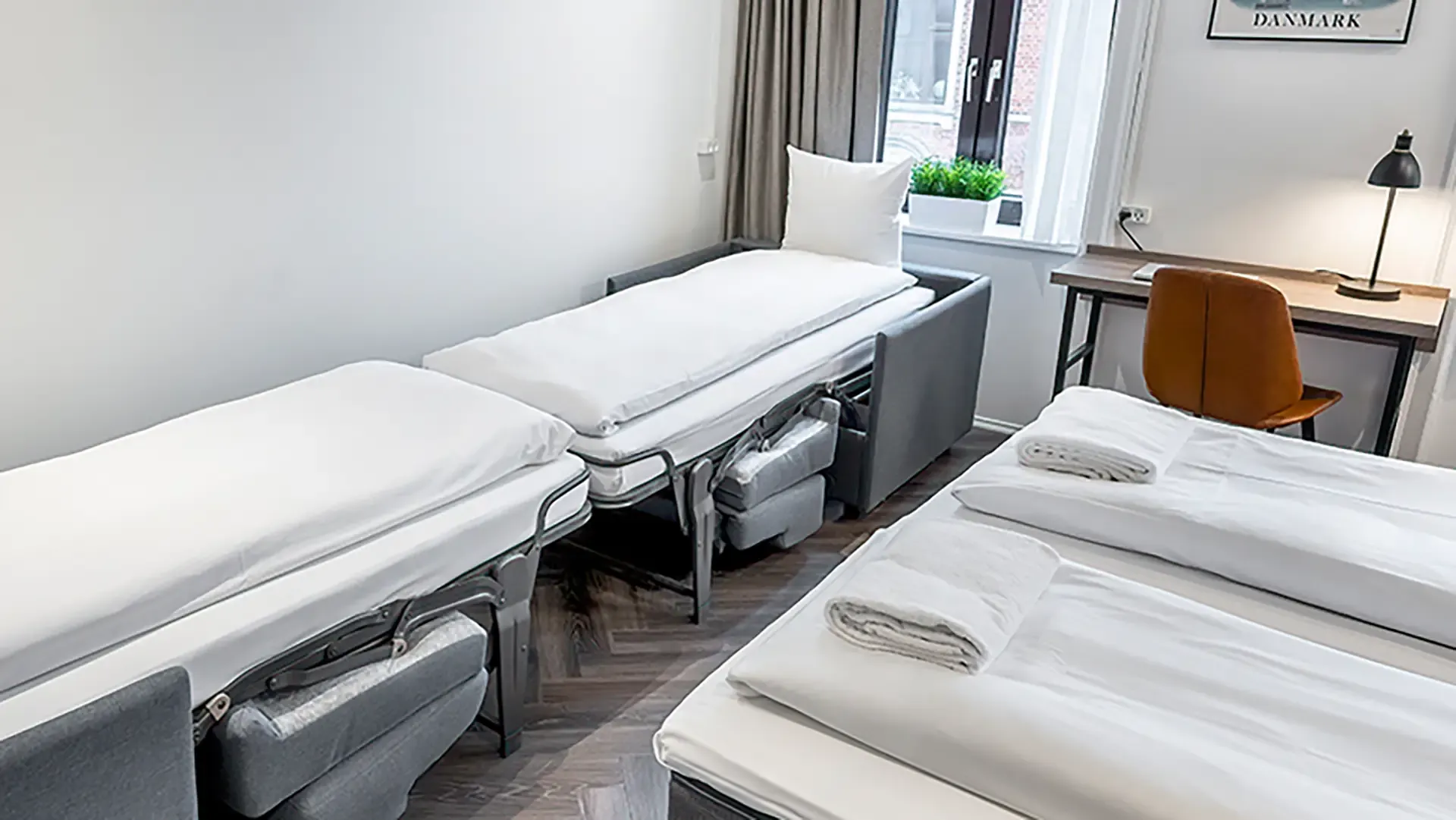 Fold-out hotel sleeping chair with white linen, ideal for small-space guest solutions.