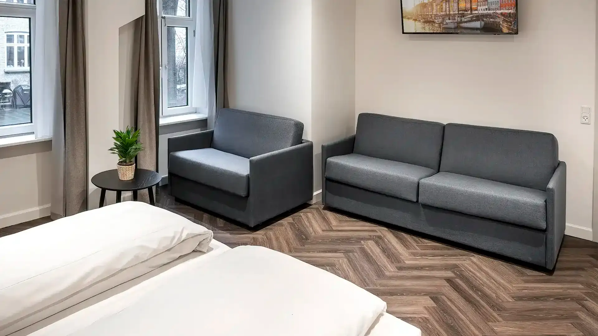 Multifunctional hotel furniture solution — grey sleeping chair in compact room layout, tailored for modern city hotels with flexible guest accommodation.