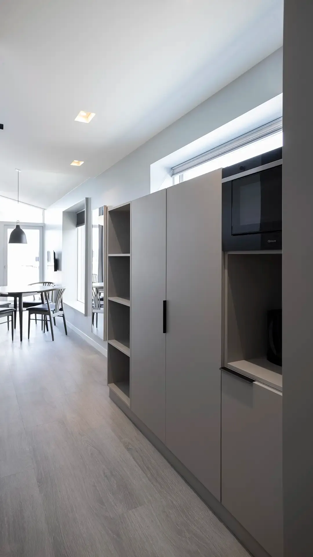 Hotel suite kitchenette with integrated storage in open-plan layout. Perfect for long-term guests.