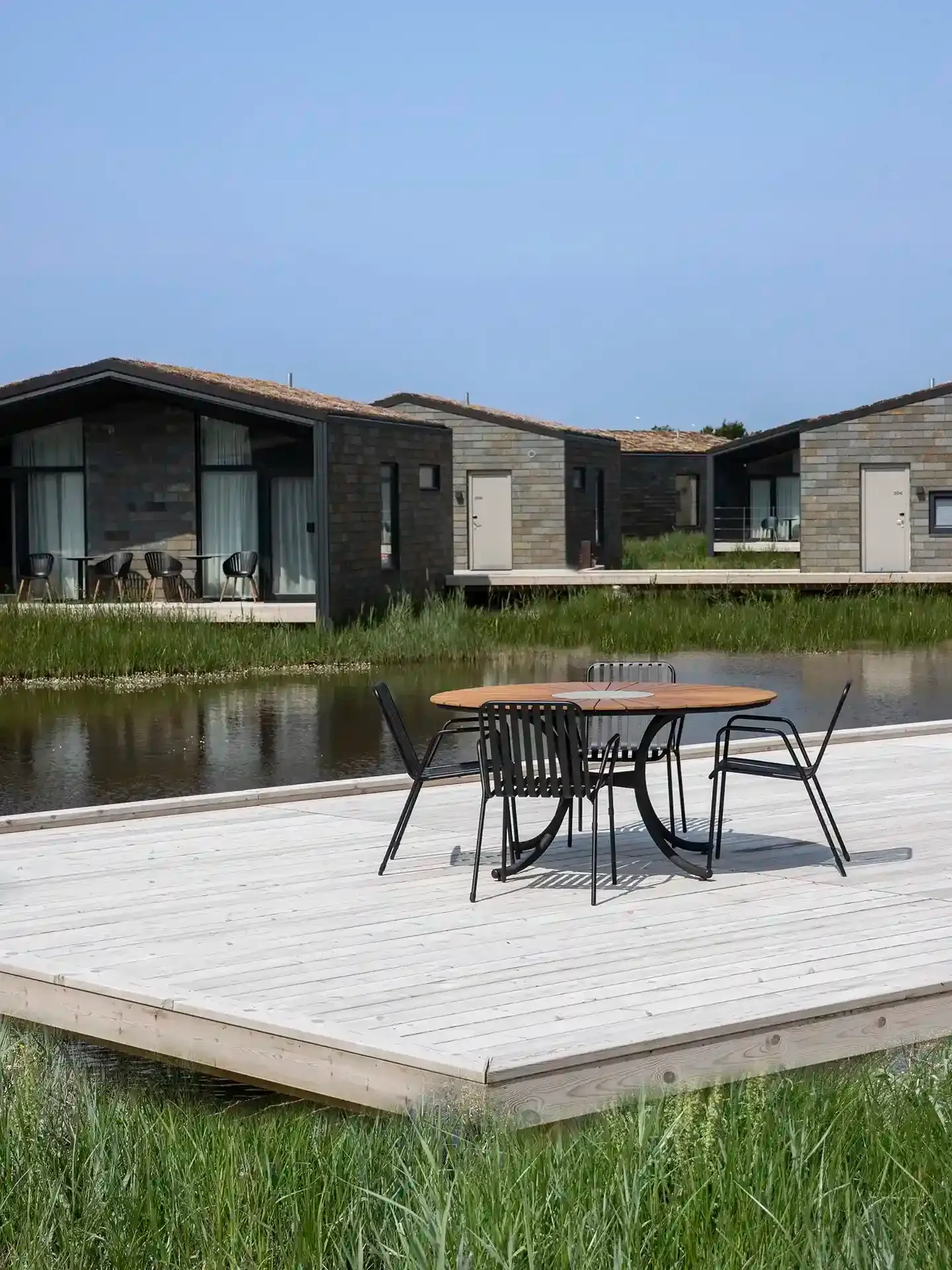 Hotel deck with outdoor seating overlooking waterfront views.