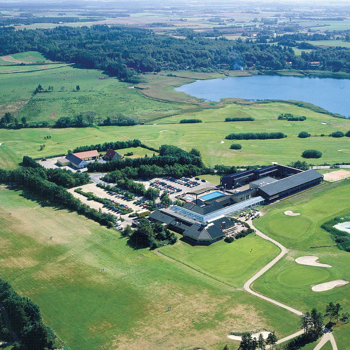 Old air photograph of HimmerLand Resort. Overview of buildings, golf courses, swimming pool, lake and farmland.