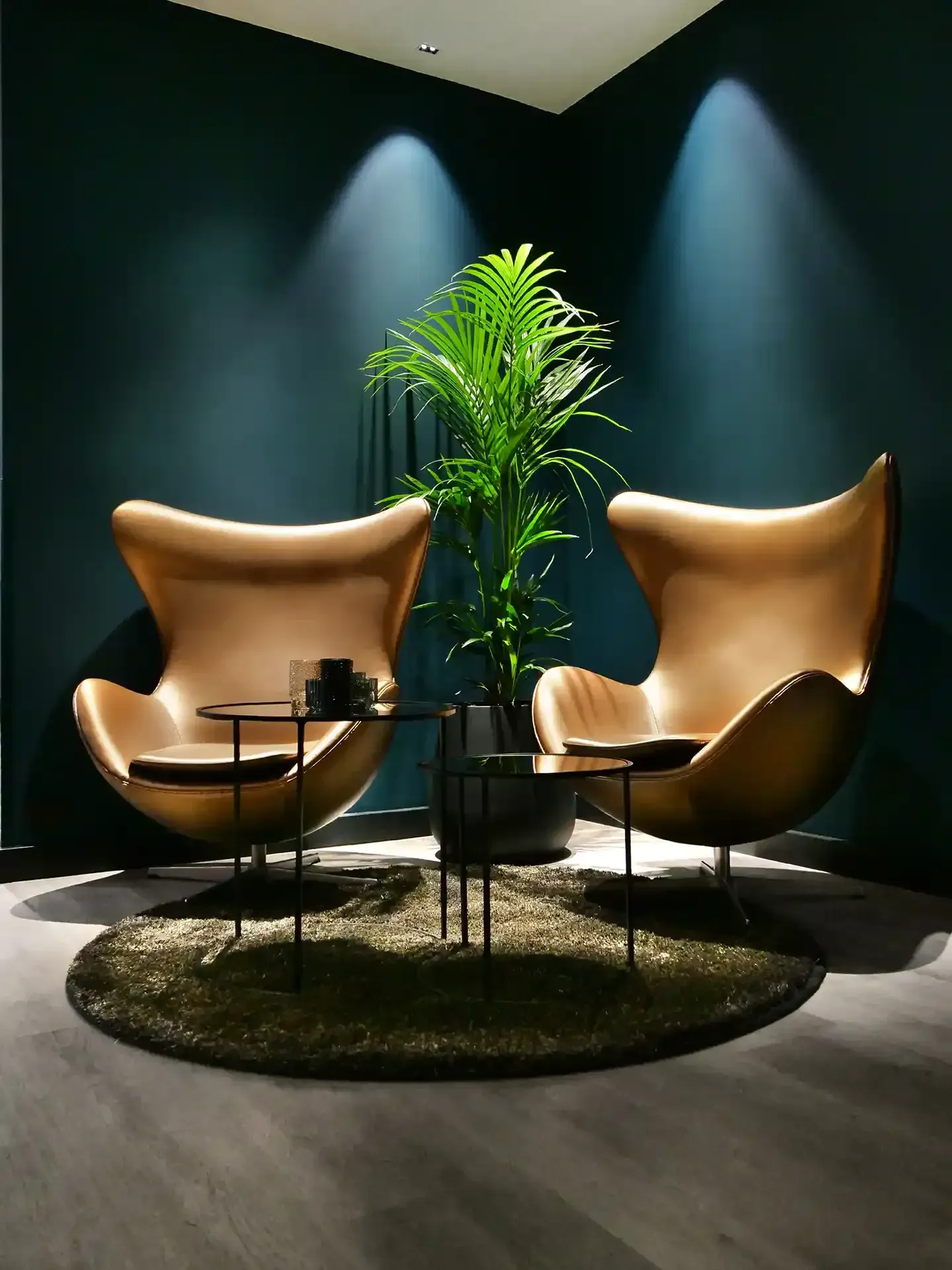 Intimate hotel lounge corner with golden Egg chairs and moody dark walls – ideal for quiet breaks or a design-conscious retreat.