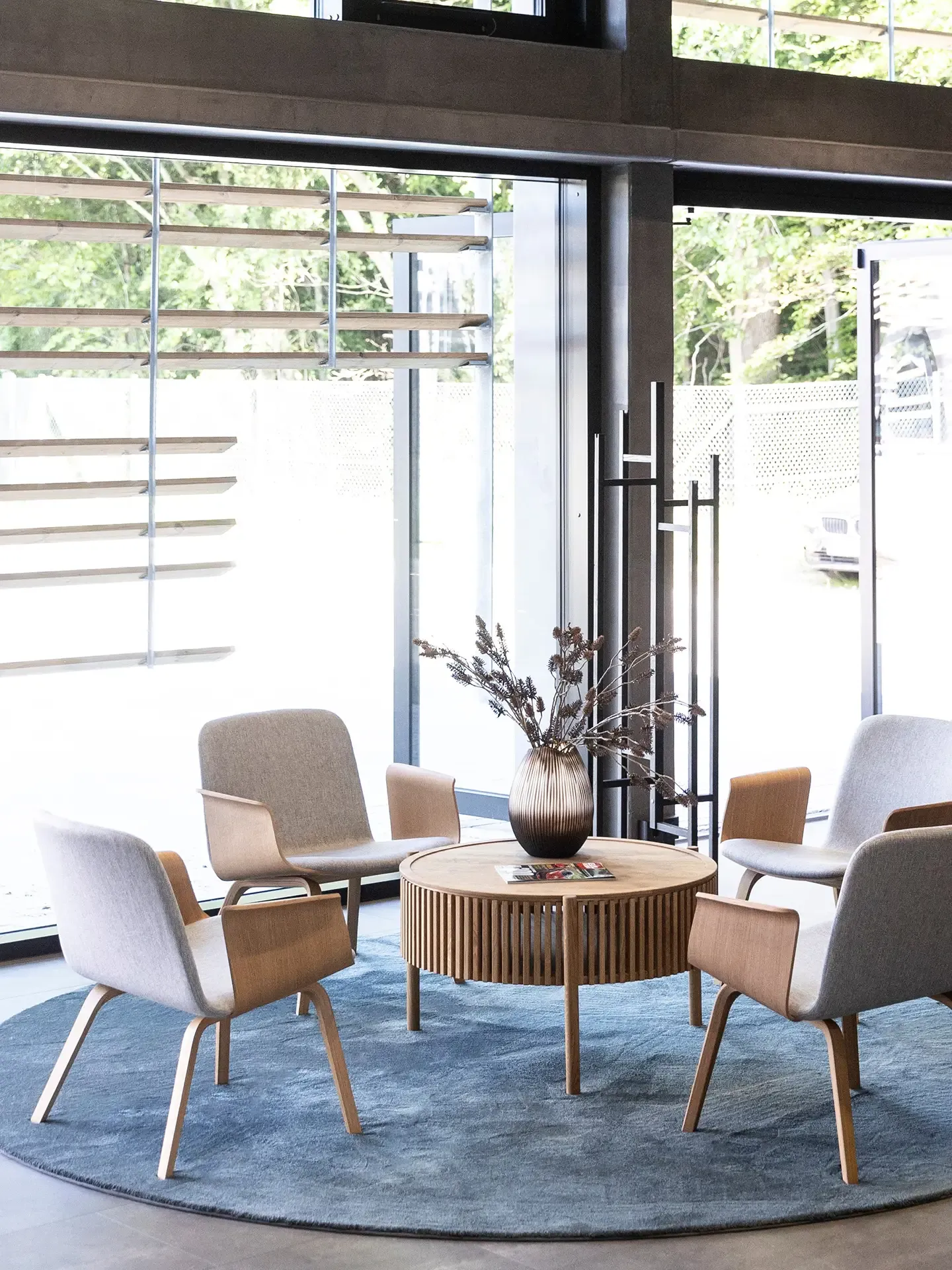 Bolia furniture lounge area in car showroom, designed for comfort and premium client experiences.