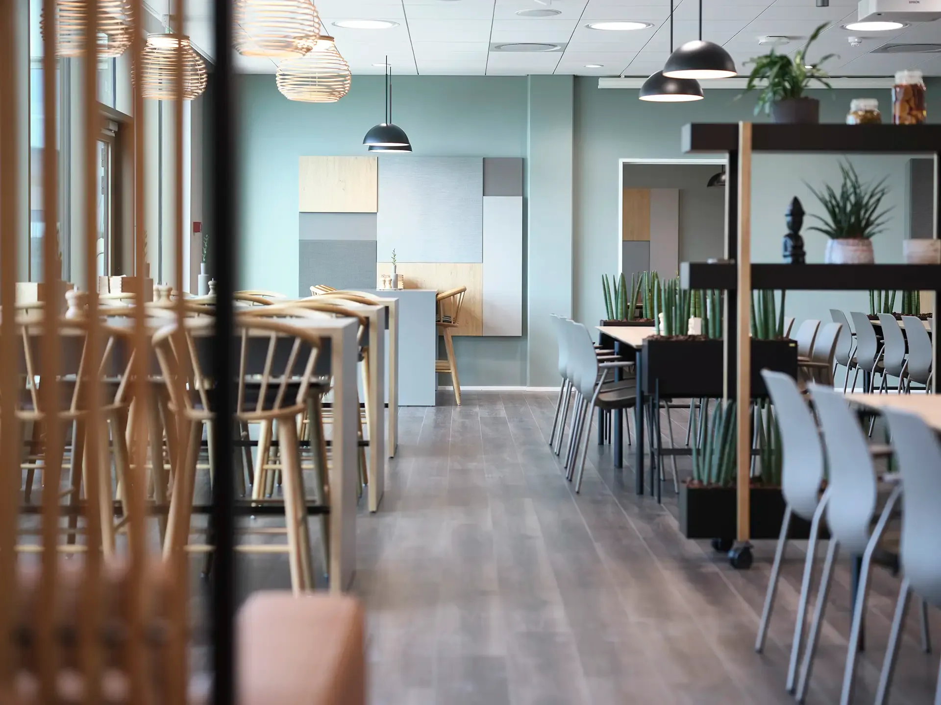Modern office cafeteria with wooden furniture and light Nordic design, offering an inviting break area for employees.