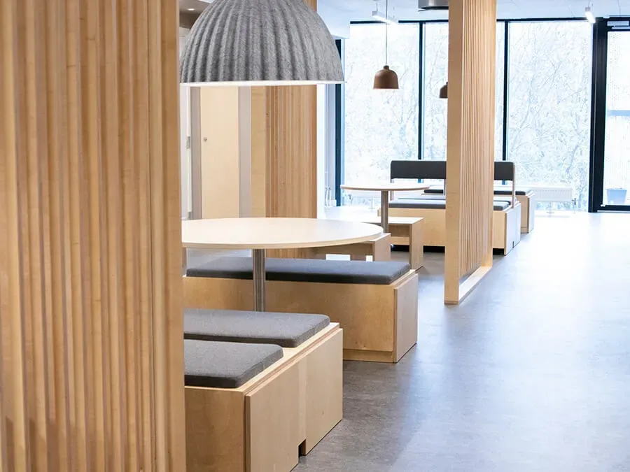 Modern student living interior with bespoke plywood furniture and integrated seating zones.