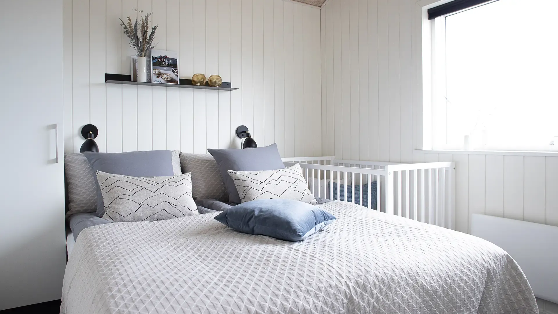 Scandinavian holiday home bedroom featuring soft textures, minimalist design, and natural light.