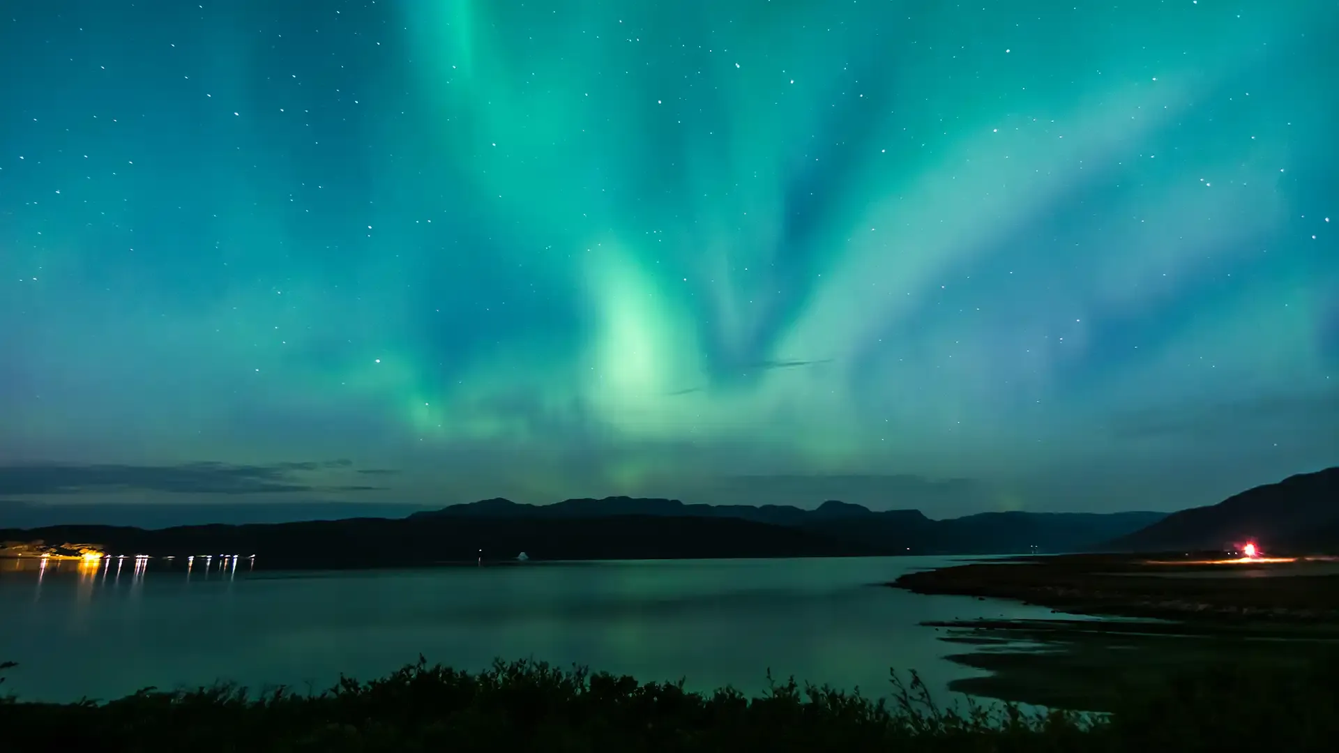 Northern Lights in Greenland with vibrant green and blue hues