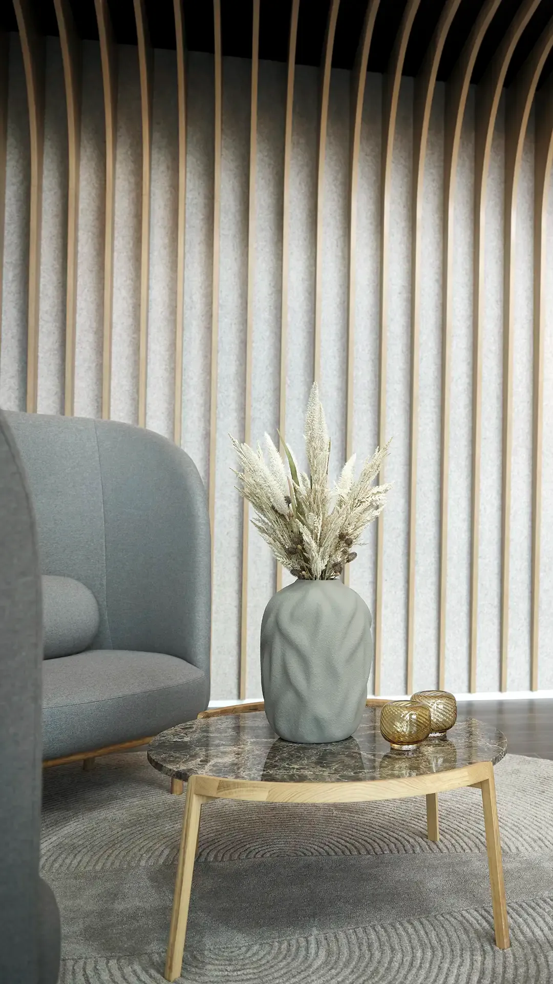 Office waiting area with Bolia chair, wooden slat wall and Scandinavian design, presenting a warm and professional look.
