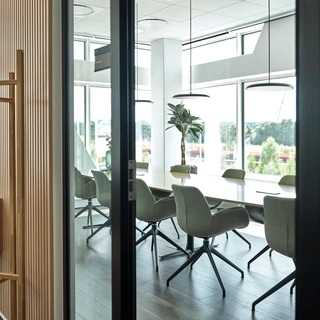 Office conference room with glass wall and natural light, delivering a bright, professional and collaborative meeting space.