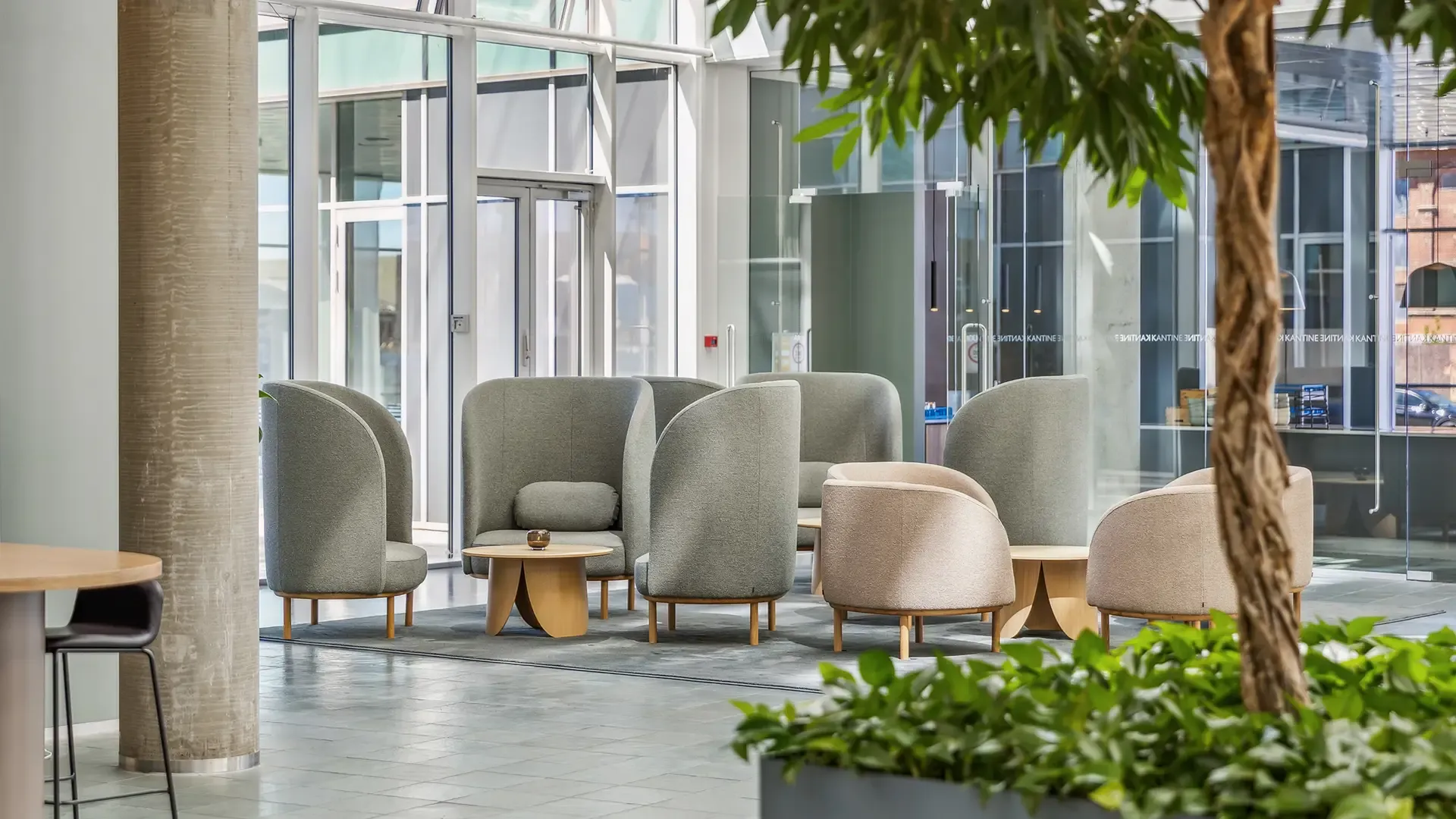 Office lounge seating with acoustic chairs and greenery by Bolia, designed for quiet zones in open-plan workplaces.