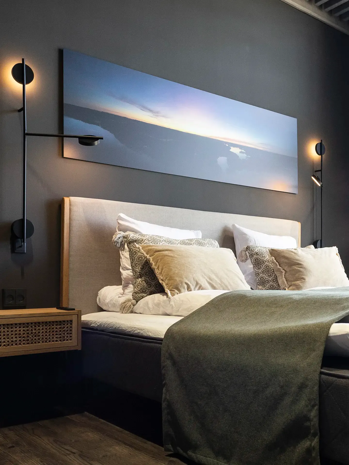 Private conference suite with upholstered bed, dark wall, and soft lighting for business stays.