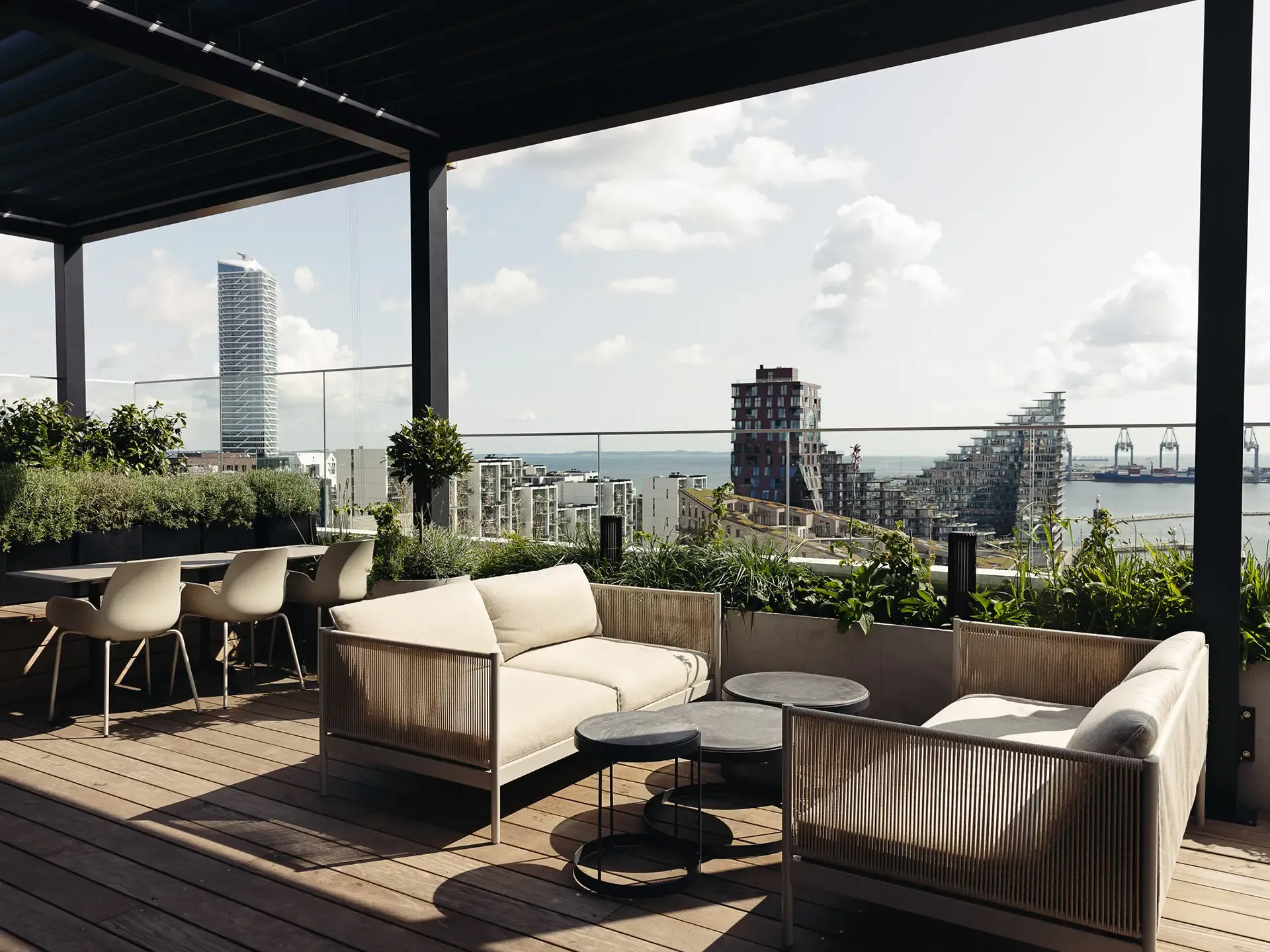 Terrace dining area with lounge furniture and scenic city views, designed for premium rooftop restaurant experiences.