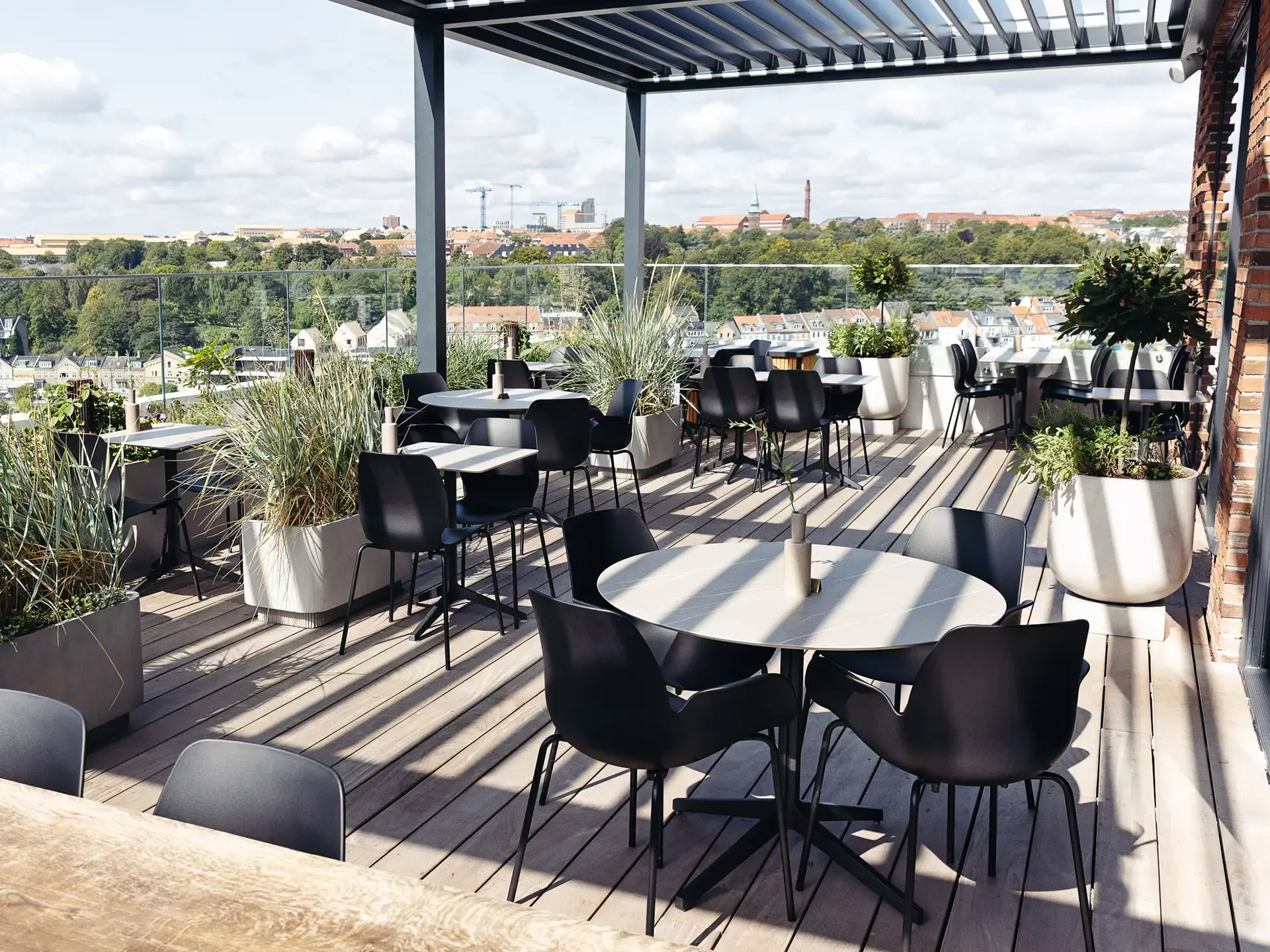 Rooftop restaurant terrace with weather-resistant furniture and city views, designed for outdoor dining and guest comfort.