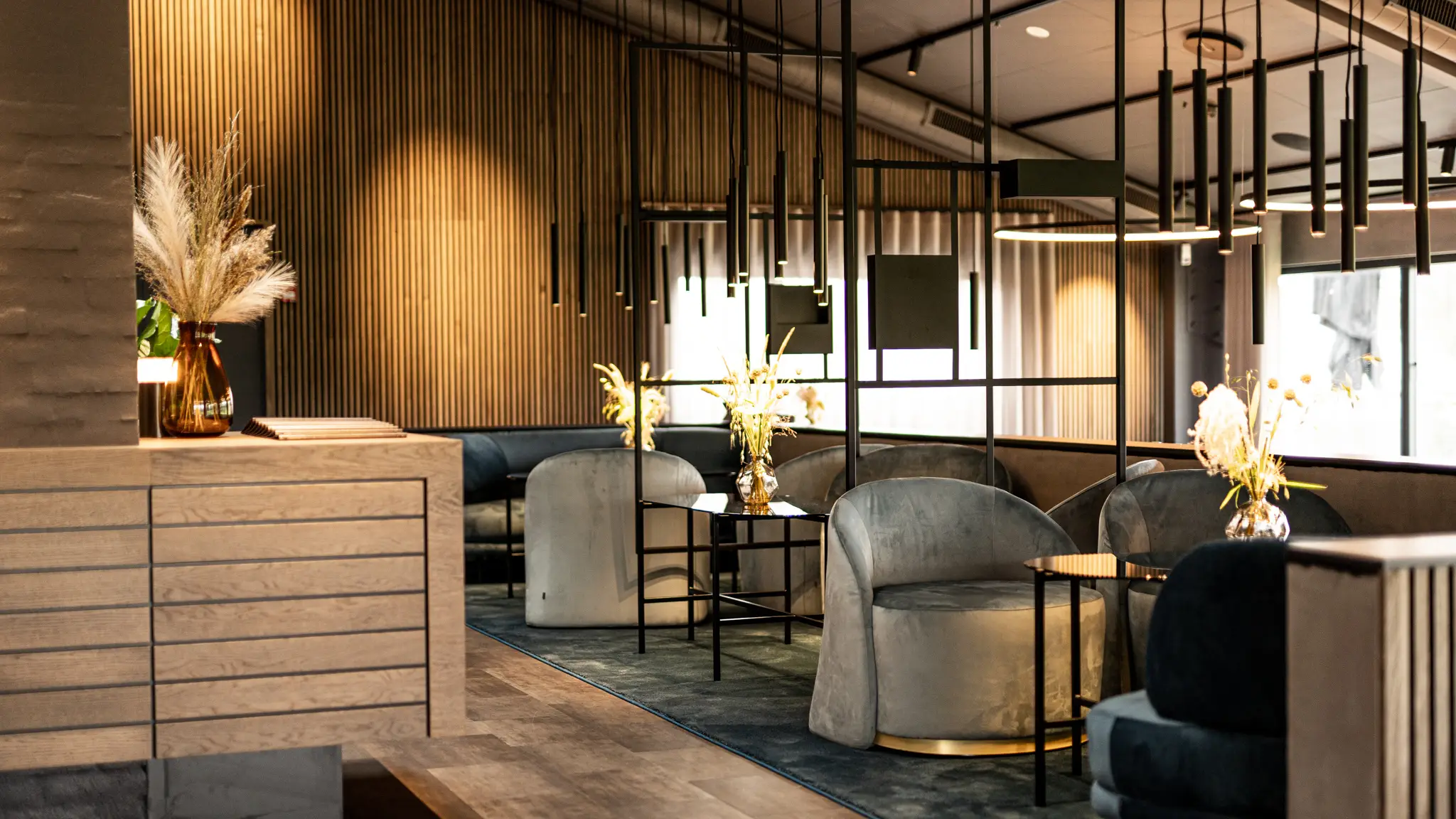 Lounge with loungechairs in velour, intimate lighting and high-quality materials.