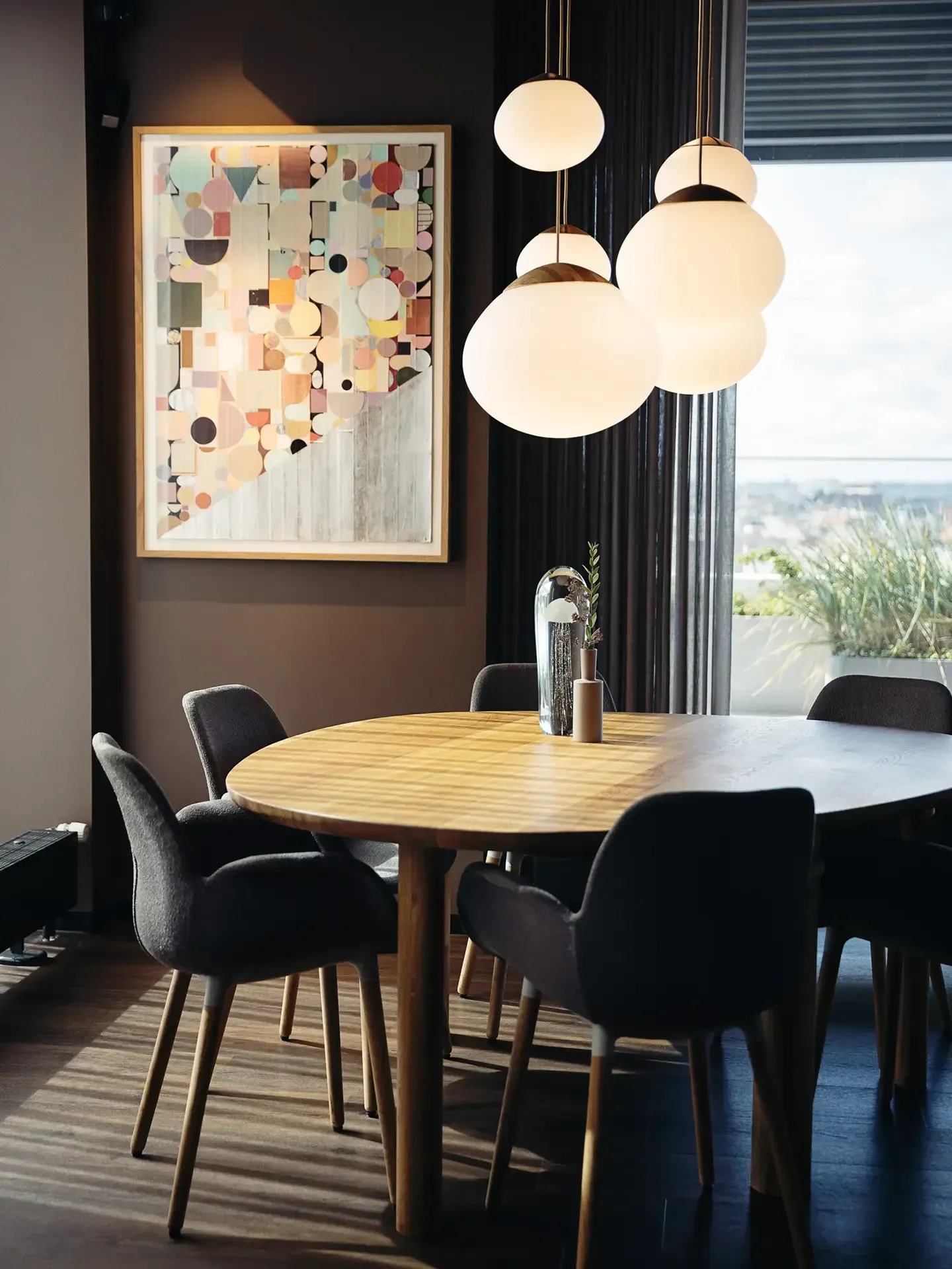 Restaurant interior with Bolia pendant lamps and modern furniture, designed for stylish evening dining.