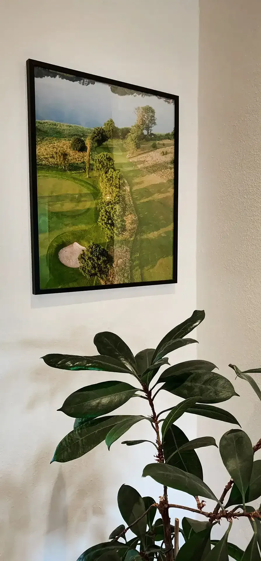 Golf club interior with wall art of course and plant