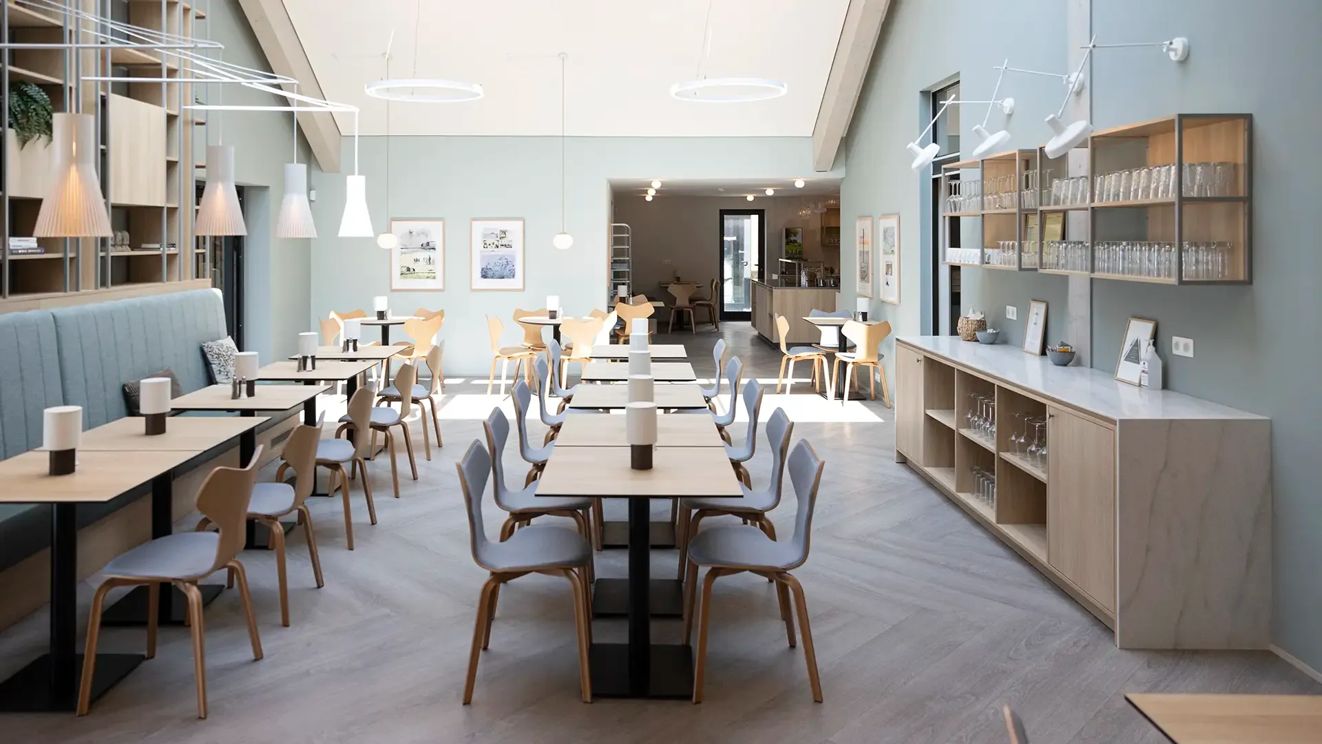 Optimised layout in Scandinavian hotel breakfast restaurant with light wood tables.