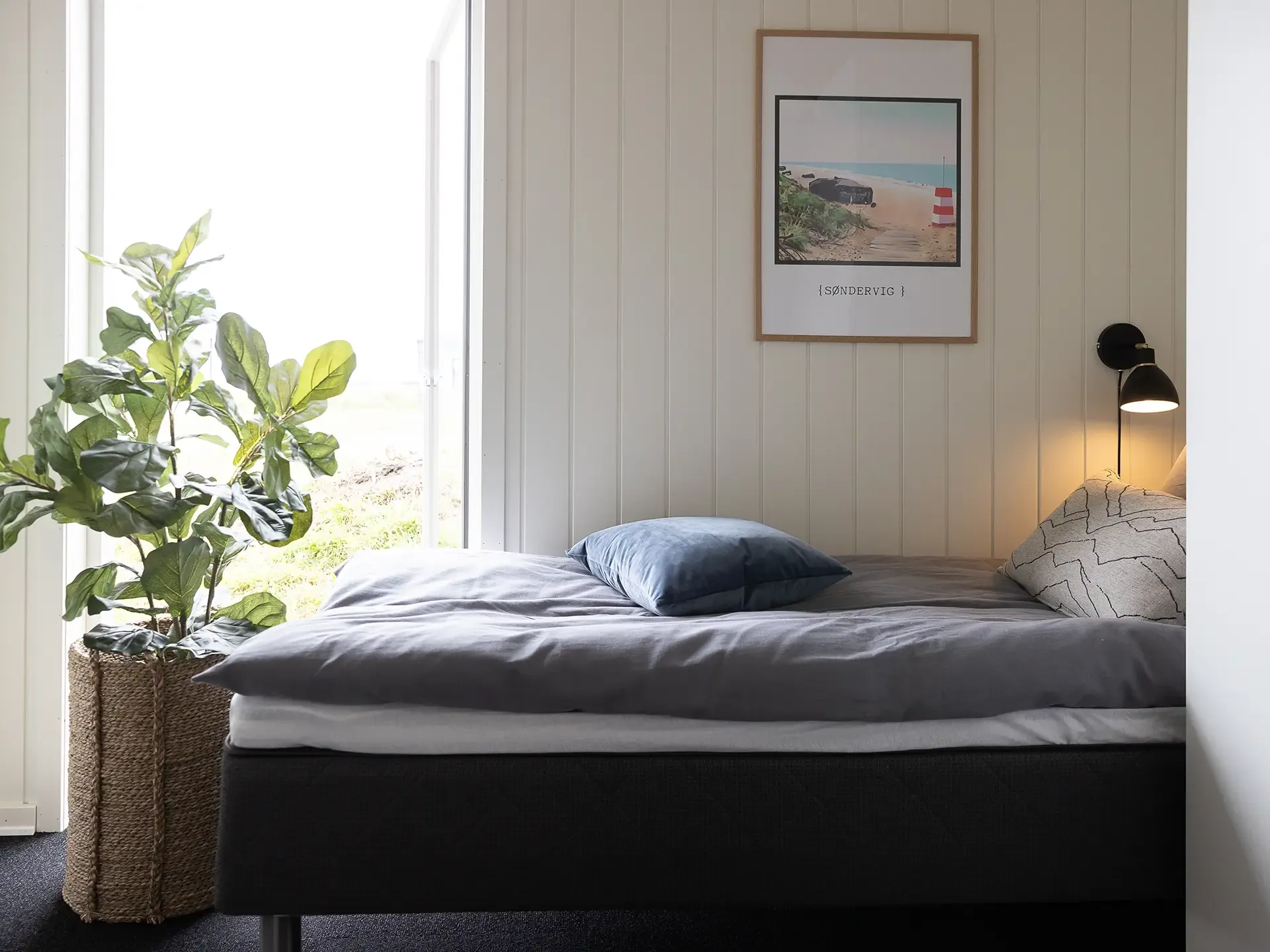 Single bed in Søndervig holiday home with poster and potted plant decor