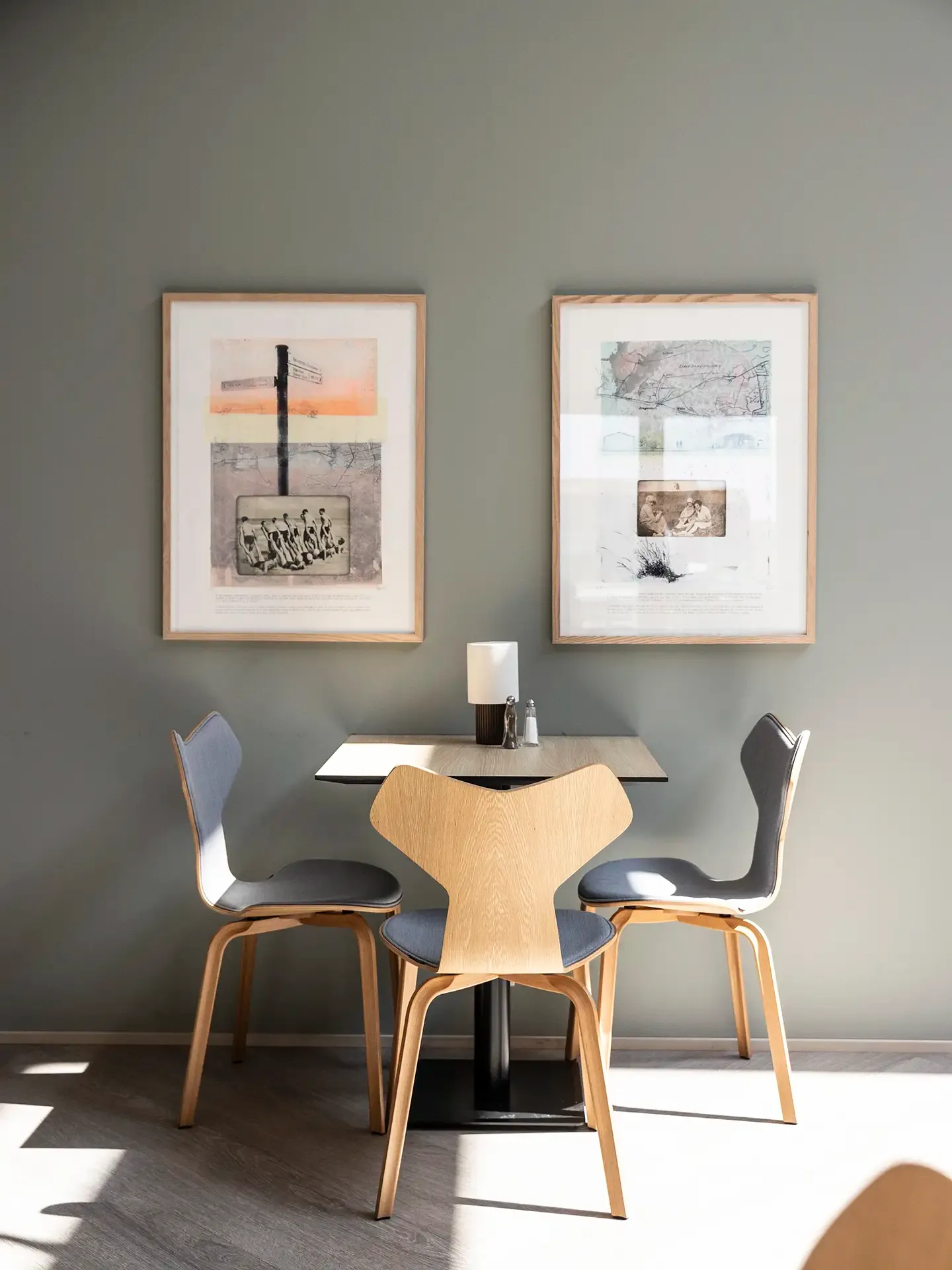 Small dining table in hotel breakfast area with custome-made wall art.