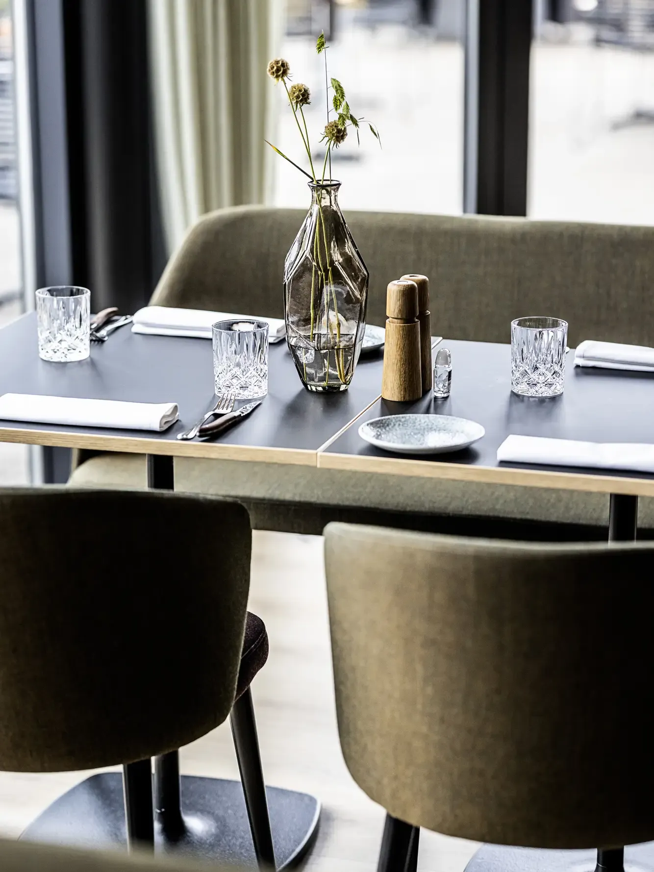 Tabelsetting at HimmerLand with fabric dining chairs and bench in green, nordic tones.