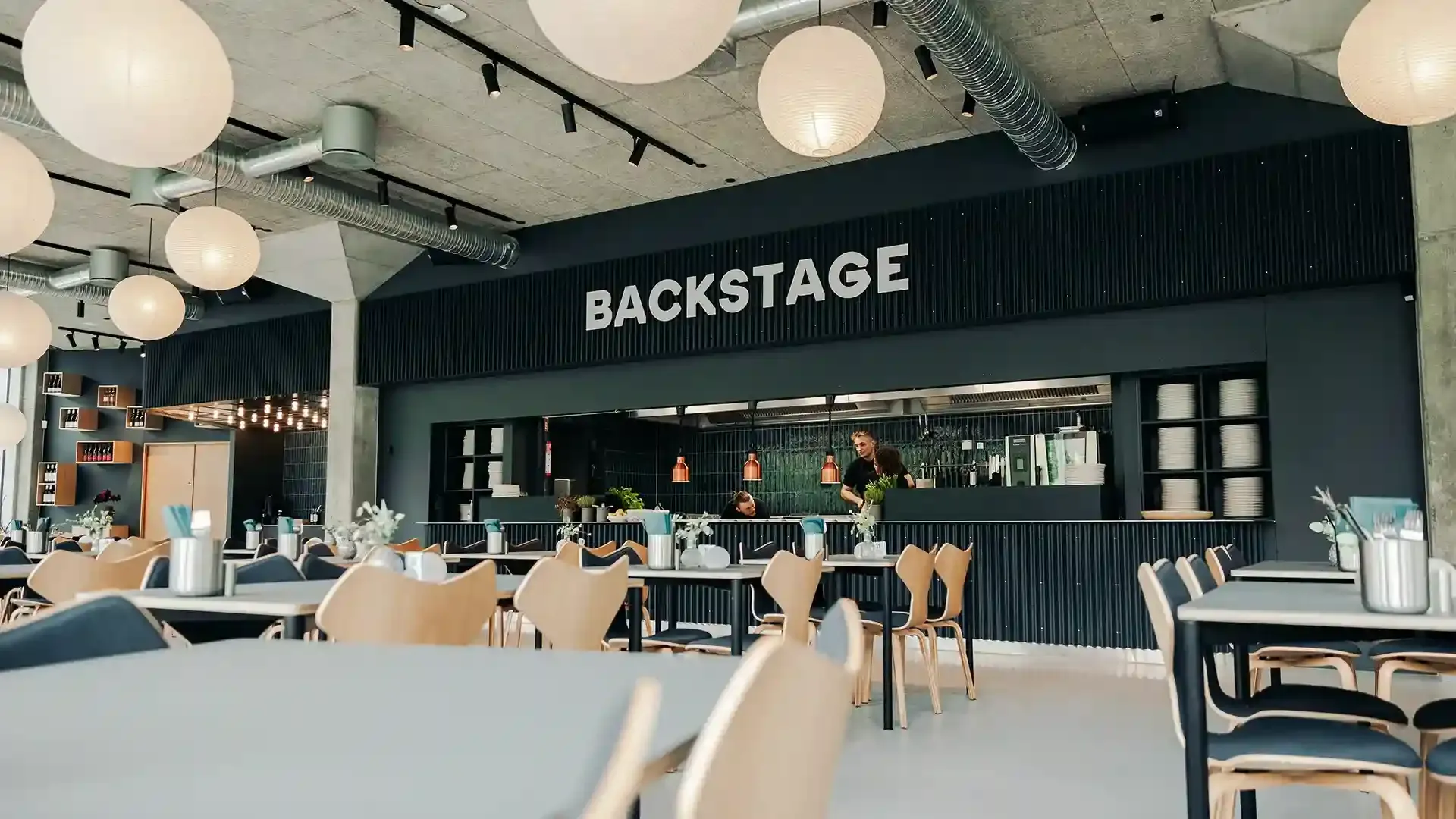 Industrial-style restaurant interior at Backstage in Tivoli Friheden, featuring durable contract furniture ideal for modern dining concepts.