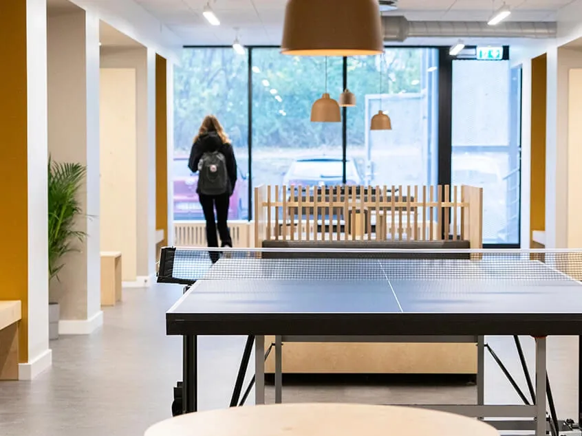 Bespoke lounge seating area featuring a ping pong table and flexible social zones in student accommodation.