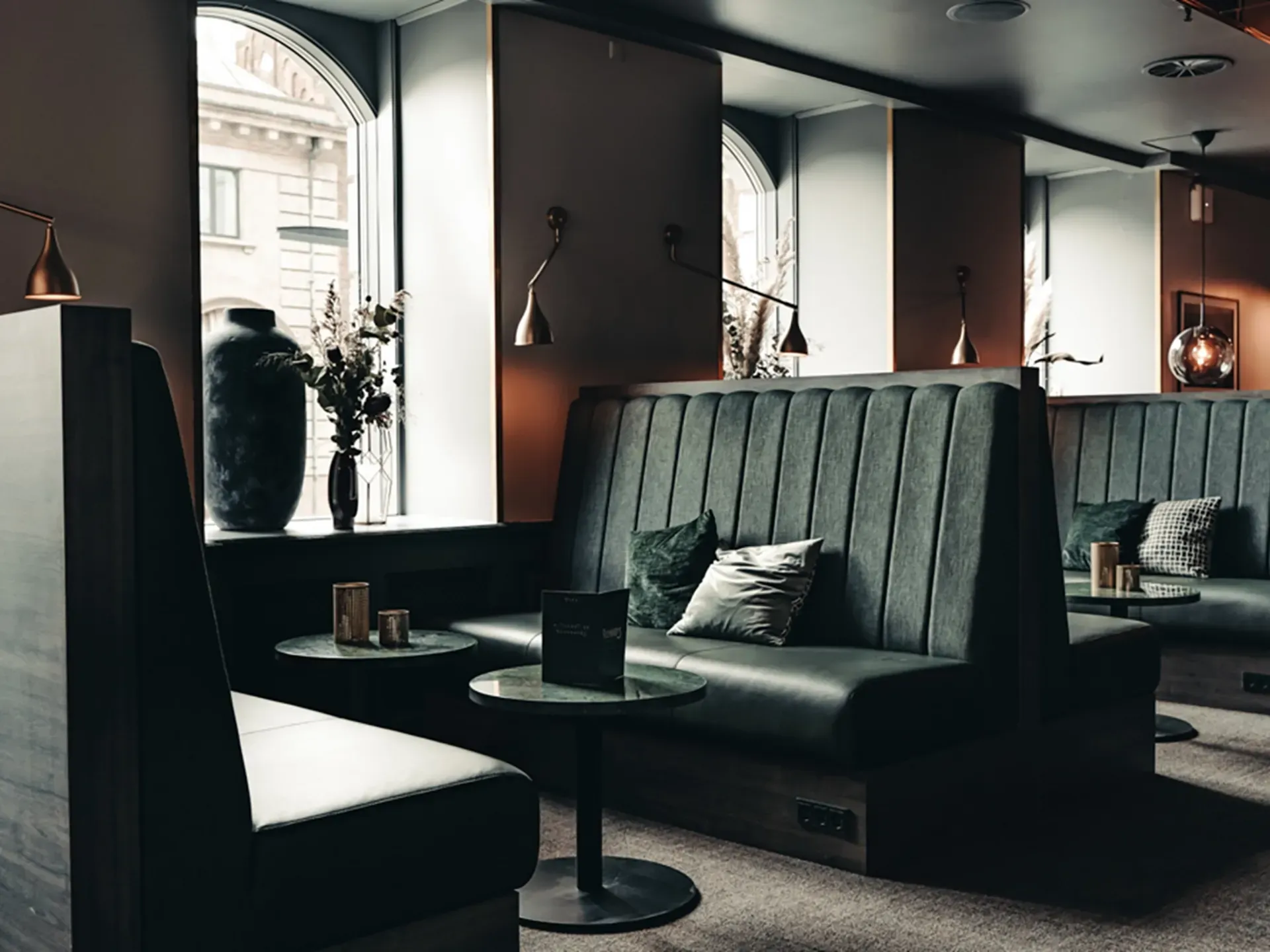 Custom high-back seating booths in a modern restaurant setting at Richards Bar, Hotel Royal.