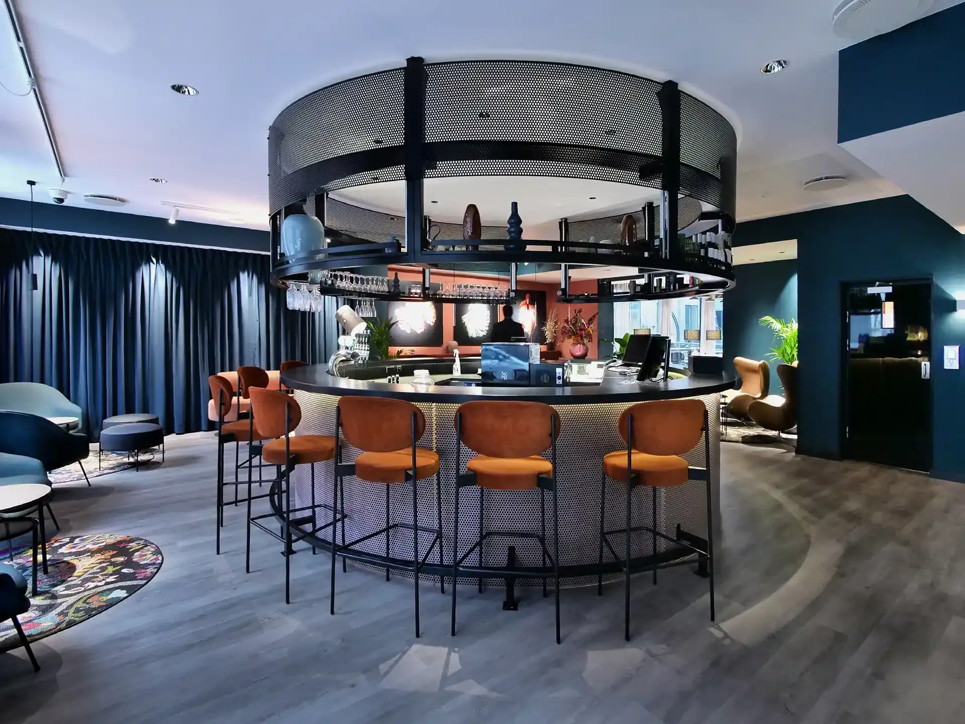 Boutique hotel reception and lounge interior combining vibrant colors with dark, sophisticated tones. Custom-made reception-bar-counter. 